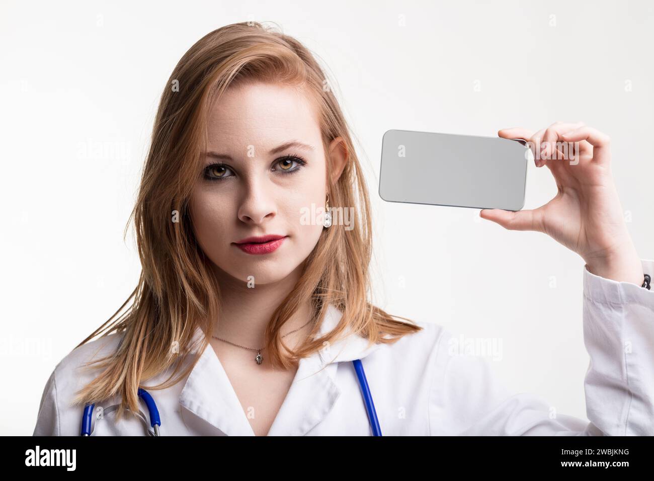 Der Arzt untersucht ein transparentes Smartphone, das die Integration von Technologie in das Gesundheitswesen symbolisiert Stockfoto