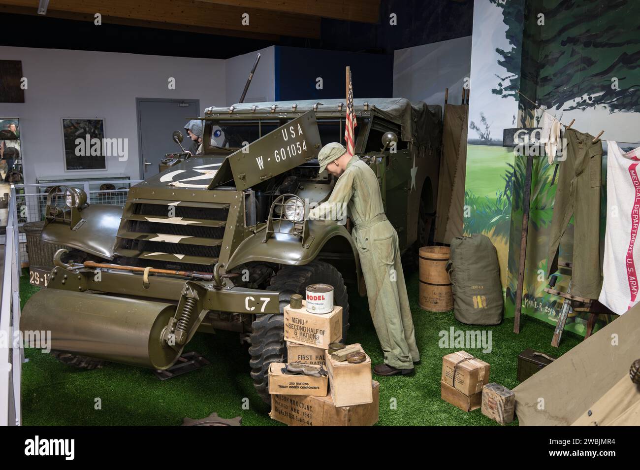 Amerikanischer Soldat, der den Motor eines M3 Scout Car M3A1 im Memorial Museum of Omaha Beach repariert und instand hält Stockfoto