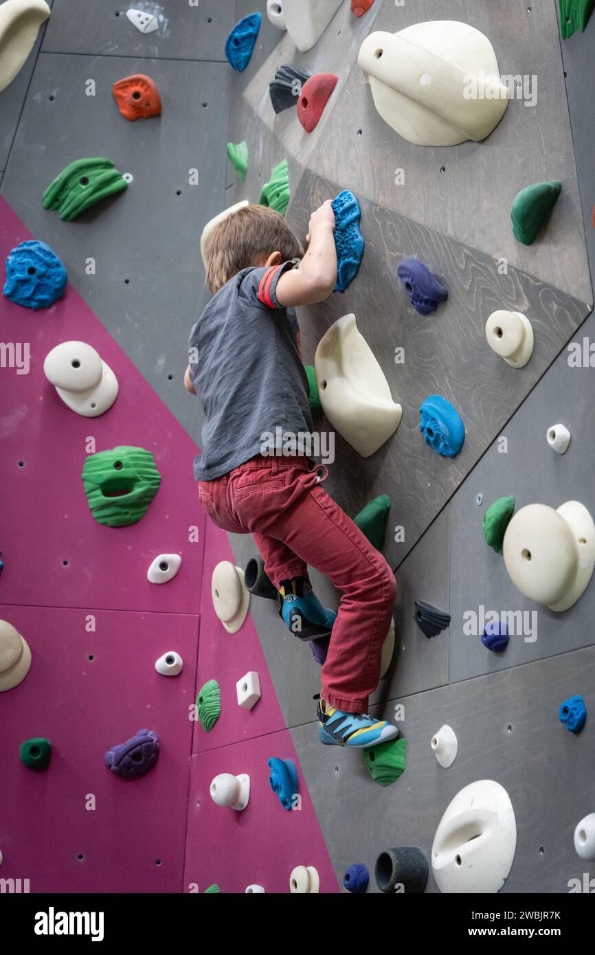 Ein kleiner Junge auf einem indoor-Kletterwand Stockfoto