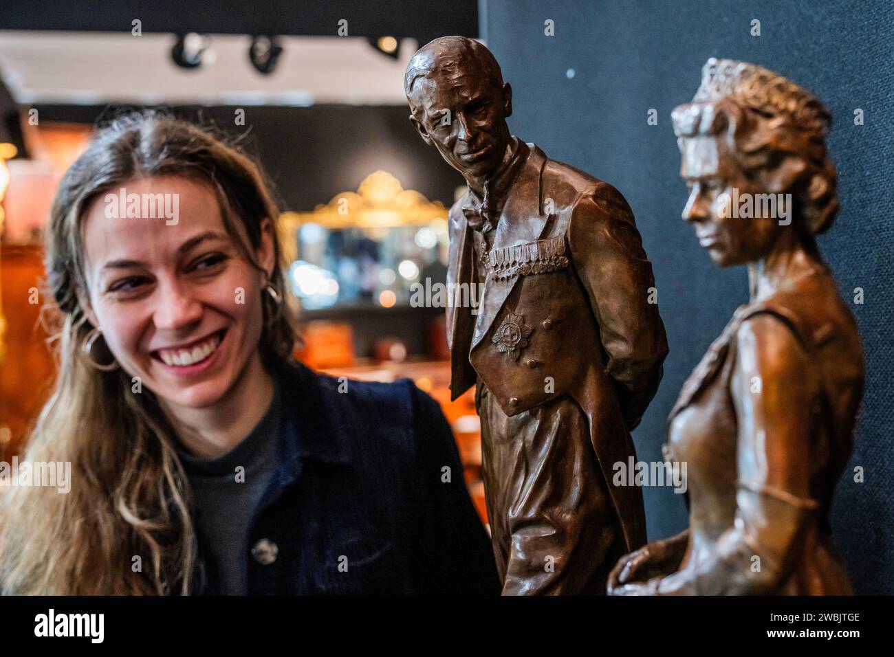 London, Großbritannien. Januar 2024. Die Queen Elizabeth Scholarship Trust Gelehrte, Poppy Field, zeigt ihre Bronzemasken ihrer Royal Albert Hall Monuments von Queen Elizabeth II und Prince Philip, die von HM King Charles III und Queen Camilla im November enthüllt wurden - die Mayfair Antiques & Fine Art Fair, London Marriott Hotel Grosvenor Square. Guy Bell/Alamy Live News Stockfoto