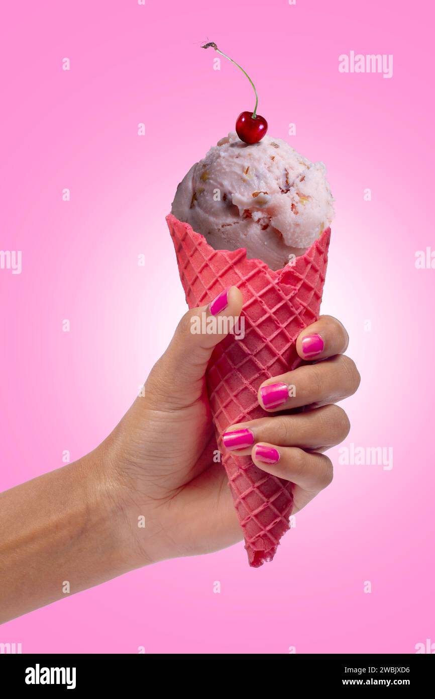 Die Hand der Frau hält Erdbeereis. Eisbecher in der Hand. Stockfoto