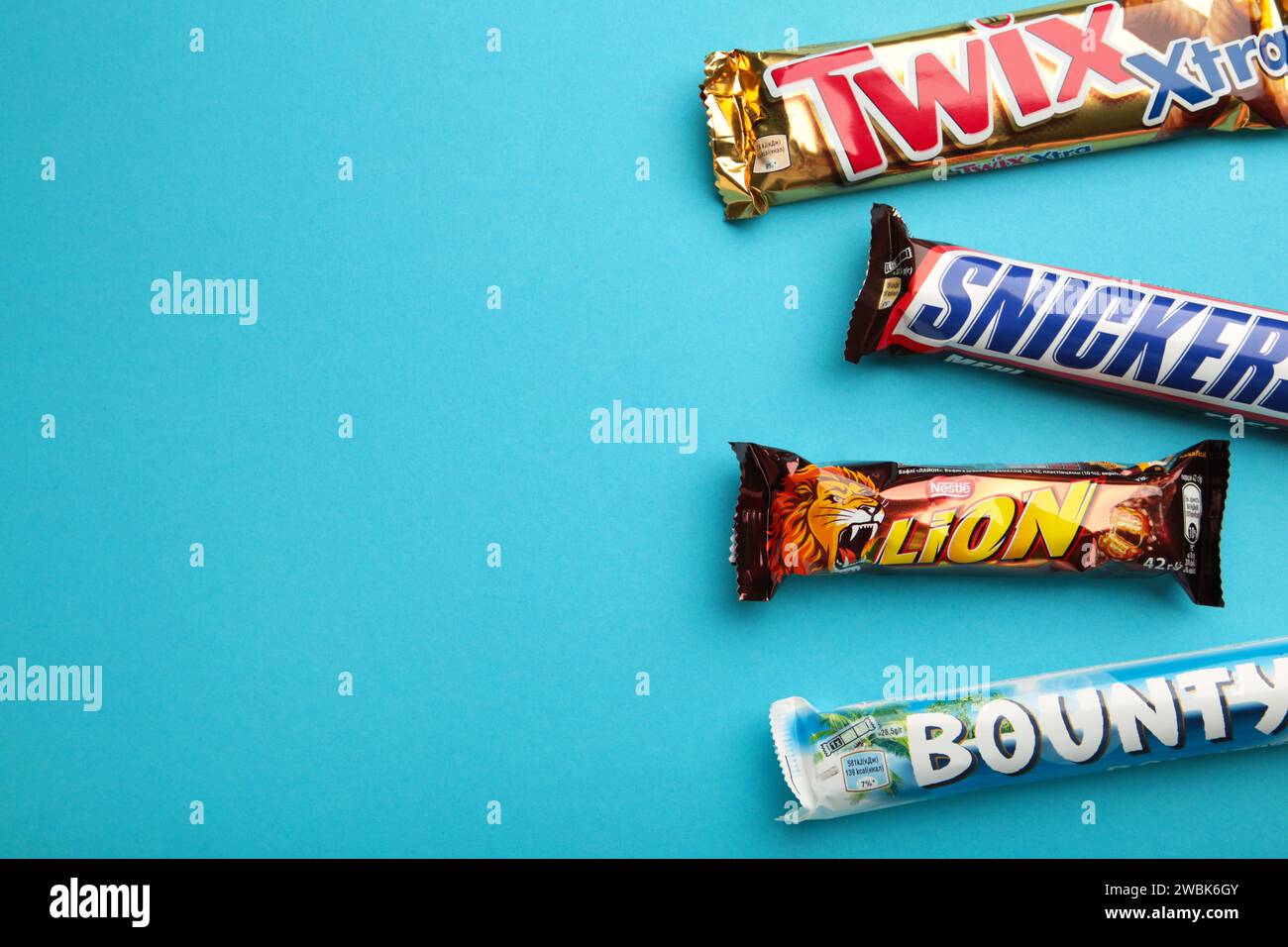 Snickers, Mars, Bounty und Twix Schokoladenriegel auf blauem Hintergrund. Draufsicht. Nikolaev, Ukraine - 19. Dezember 2021 Stockfoto