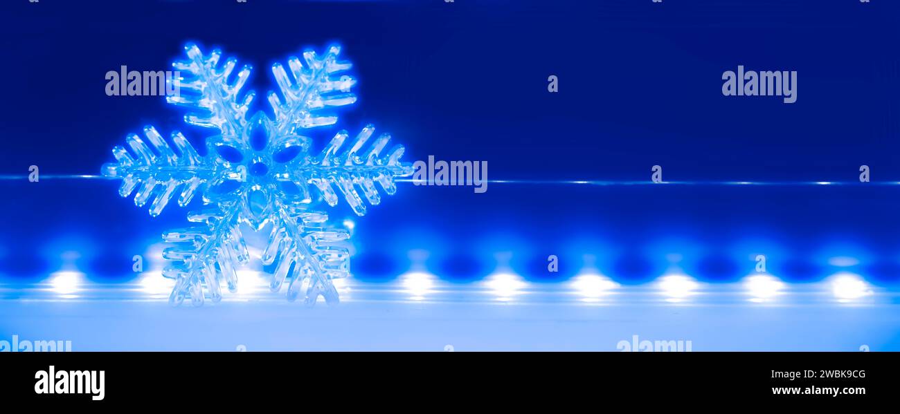 Leuchtend blauer Weihnachtsstern vor einem verschwommenen Hintergrund mit Bokeh-Effekt Stockfoto