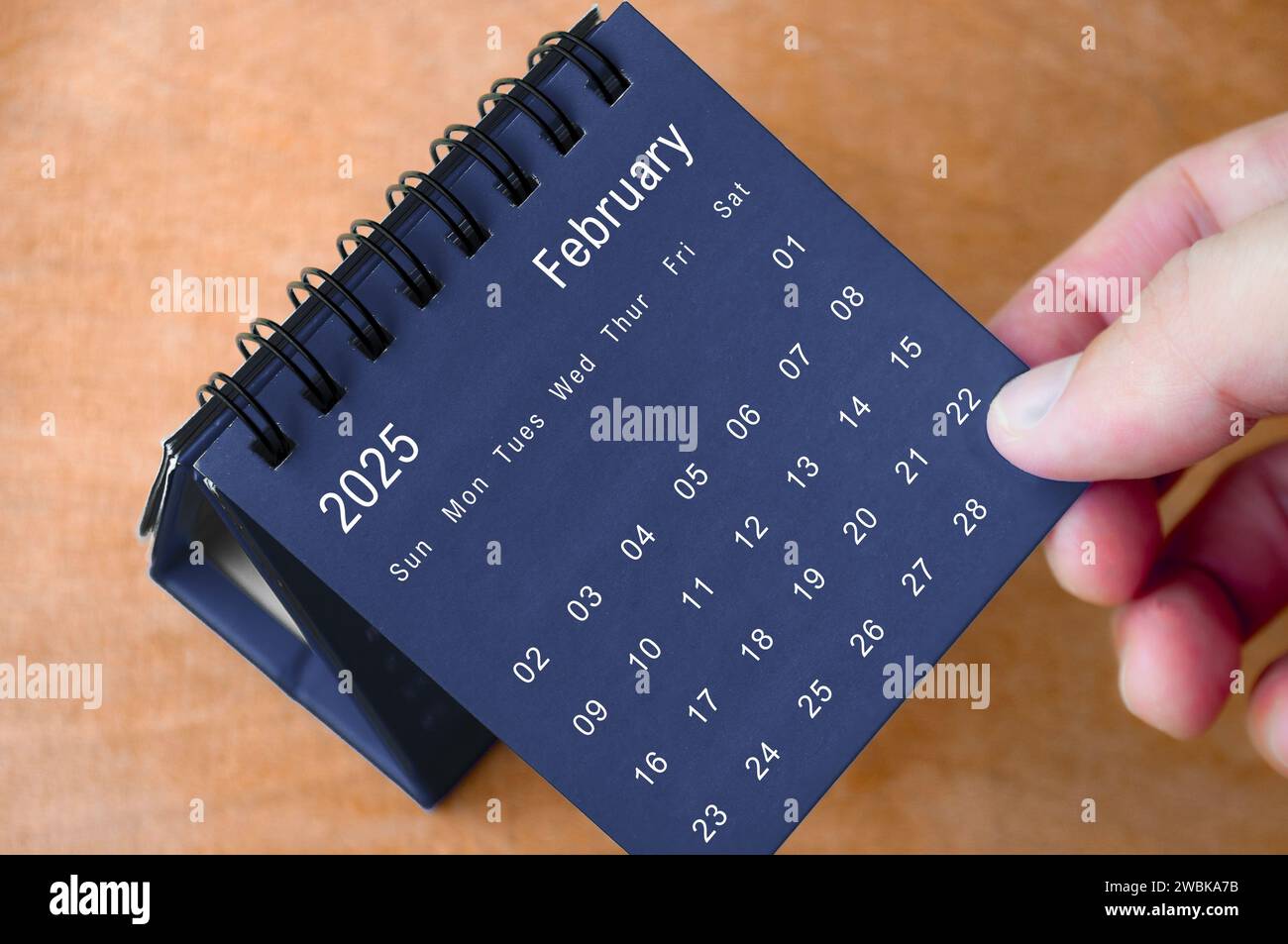 Februar 2025 schwarz-weißer Kalender auf Holzschreibtisch. Kalender- und Neumonatskonzept. Stockfoto