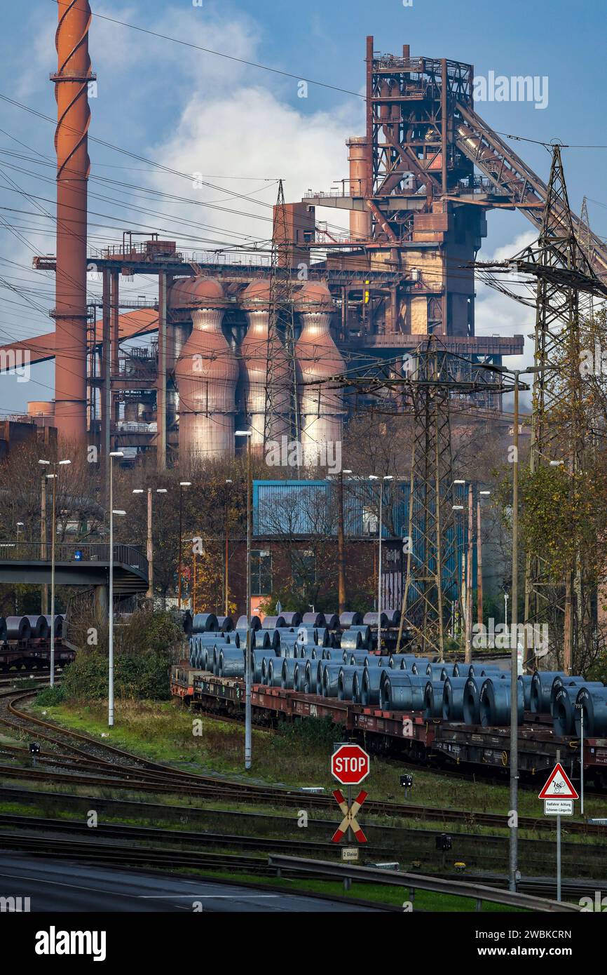 Duisburg, Ruhrgebiet, Nordrhein-Westfalen, Deutschland - ThyssenKrupp Steel Europe, hier Hochofen Schwelgern 2 in Duisburg-Marxloh, vorne Stahlspulen aus dem Warmbandwerk Kühlung auf Güterwagen im Außenbereich. Stockfoto