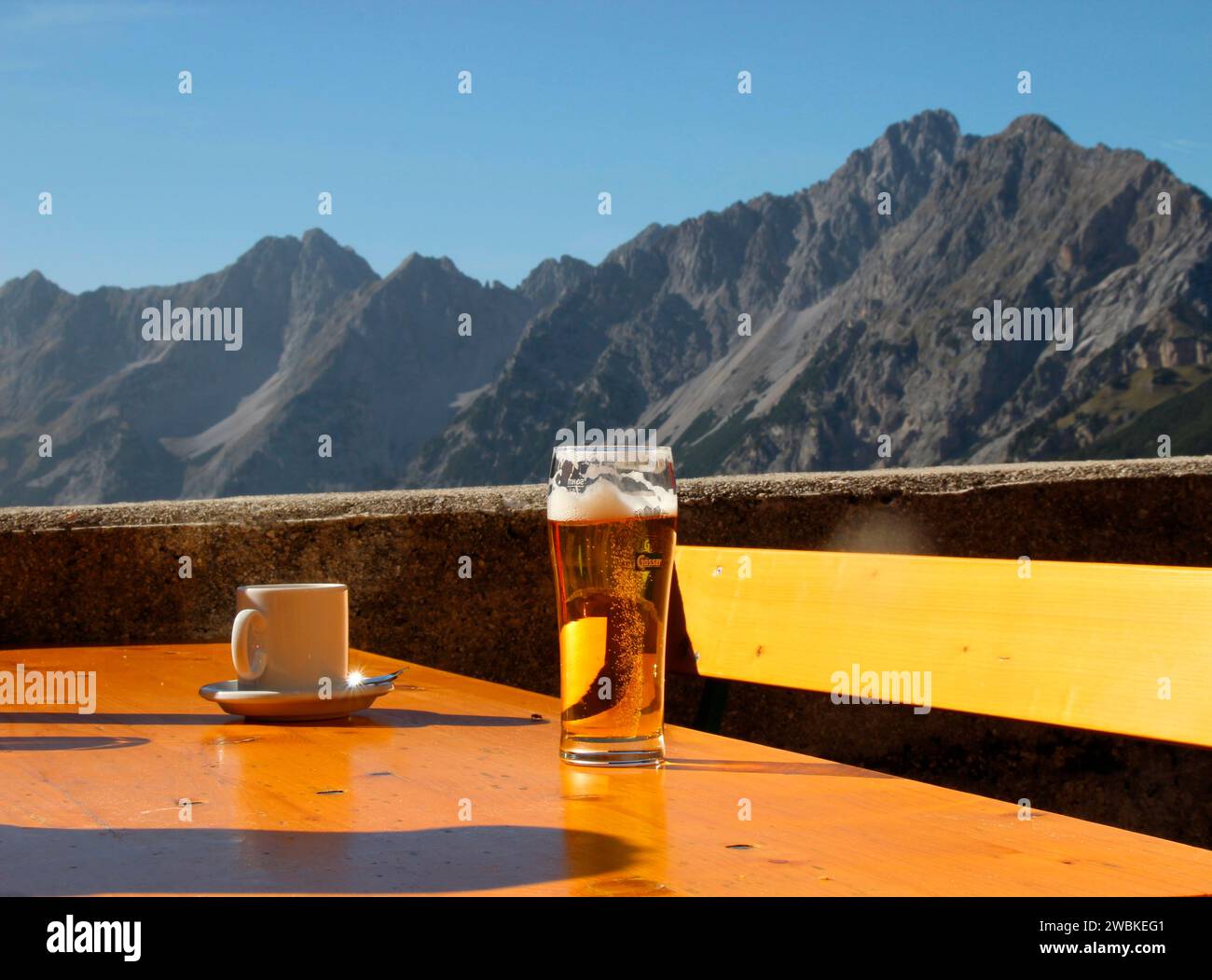 Wanderung zur Birkarspitze höchster Berg im Karwendel 2749m, Rast am Karwendelhaus 1765, Tisch mit Kaffeetasse und halbem Bier, im Backgr Stockfoto