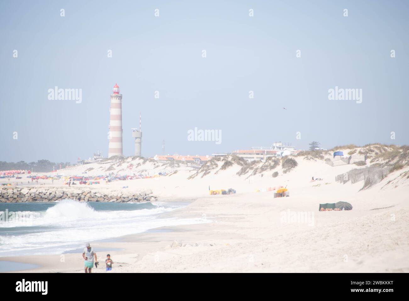 Der Strand von Costa Nova do Prado bei Aveiro und der Leuchtturm von Praia da Barra an der Atlantico Küste Portugals Stockfoto