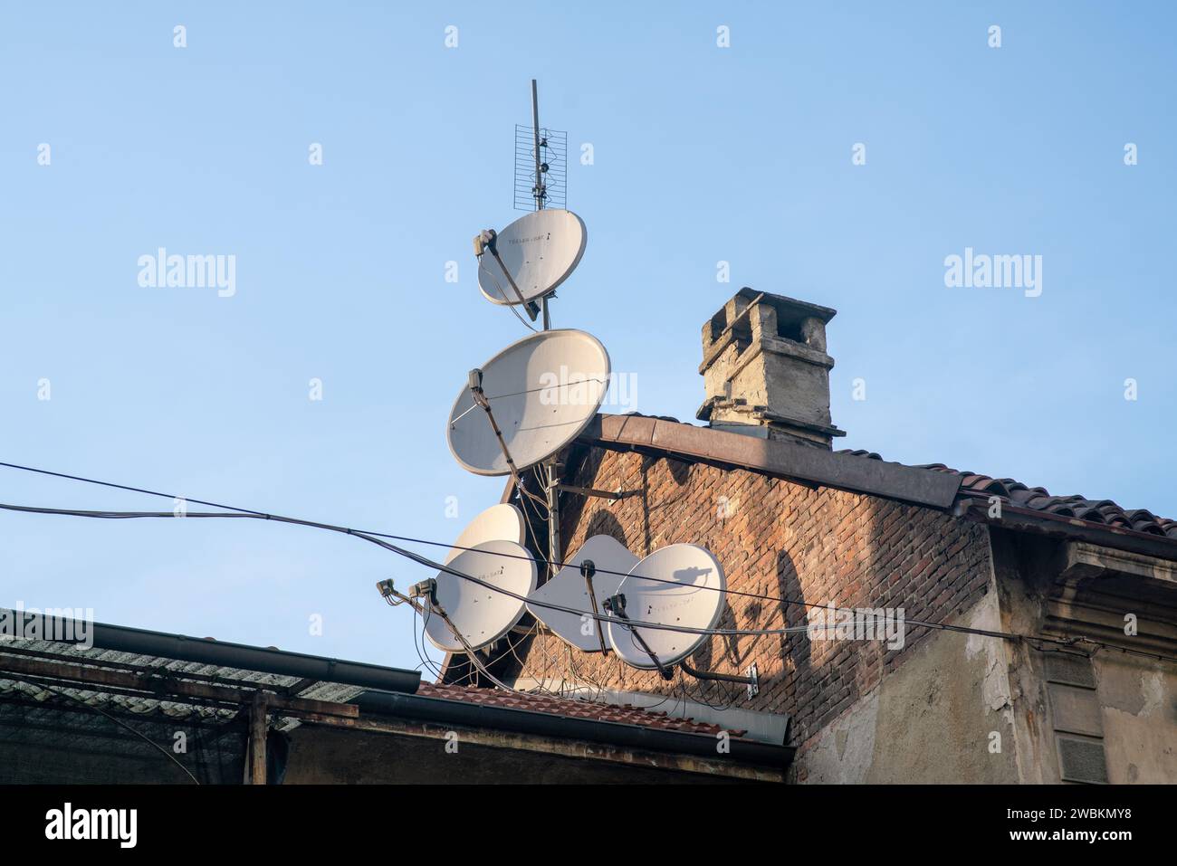 Satellitenschüsseln auf den Dächern, immer schnellere Kommunikation und Pay-TV ohne Werbung Stockfoto