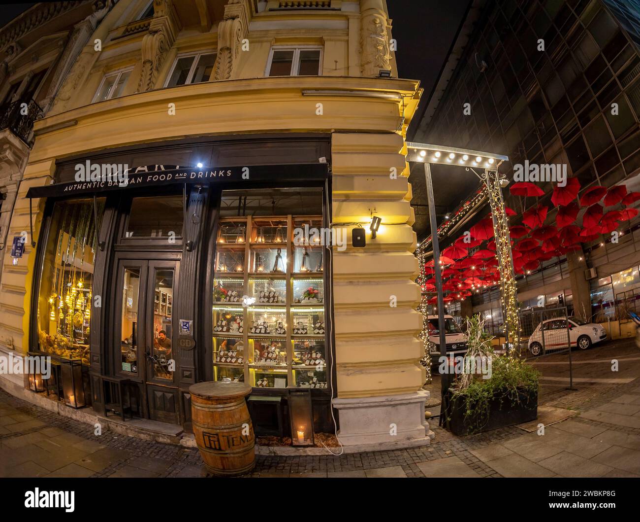 BELGRAD, SERBIEN - 4. MÄRZ 2020: Authentisches Balkan Food and Drink Restaurant und lustige Terrasse mit roten Sonnenschirmen in der Innenstadt. Stockfoto