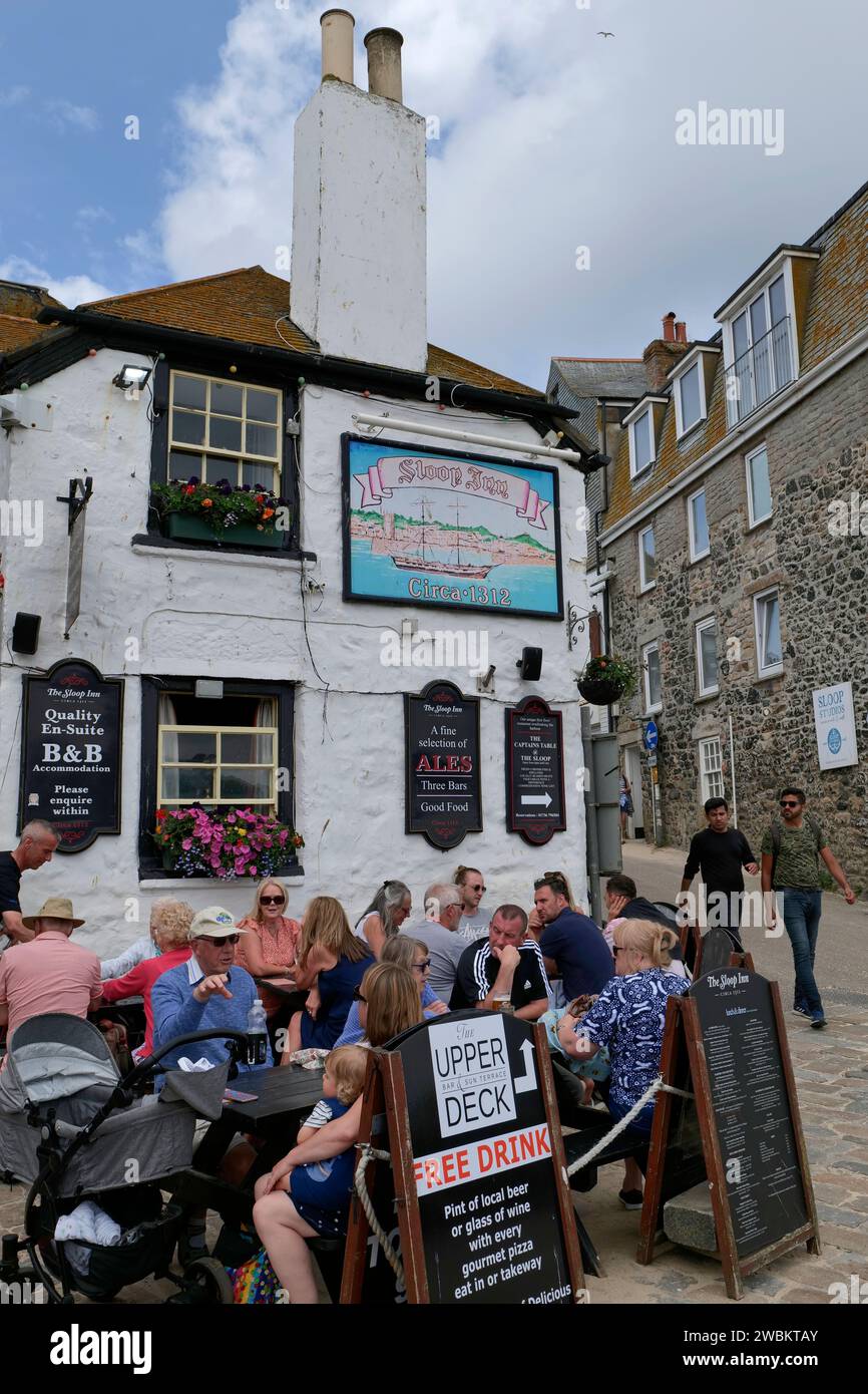 Im historischen Sloop Inn Pub in St Ives, Cornwall, England, Großbritannien, können Gäste im Freien essen und trinken Stockfoto