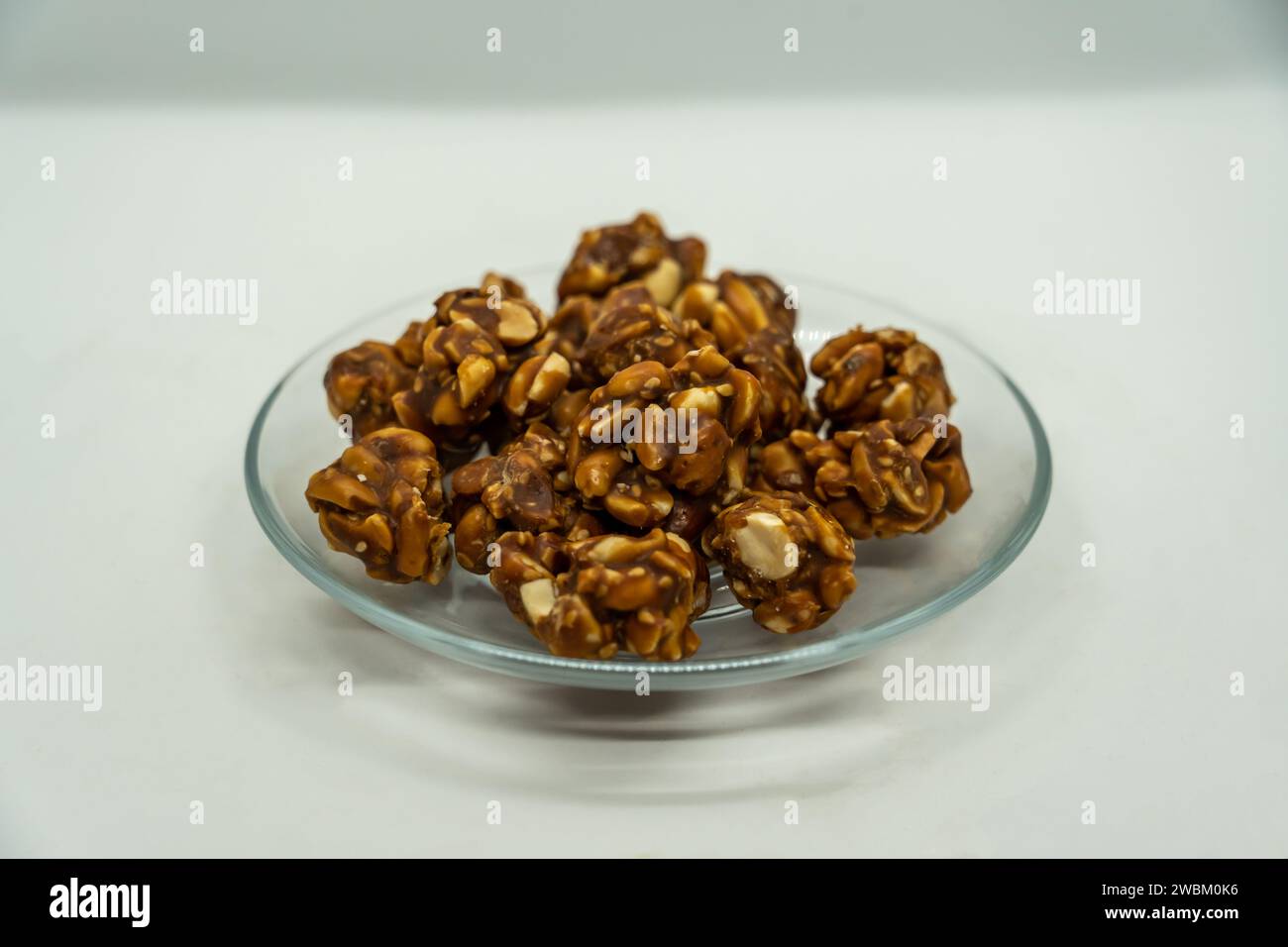 Eine Platte mit Erdnuss Ladoo für Makar Sankranti, die Peantus in süße Zackengud in Nepal und Indien getaucht ist Stockfoto