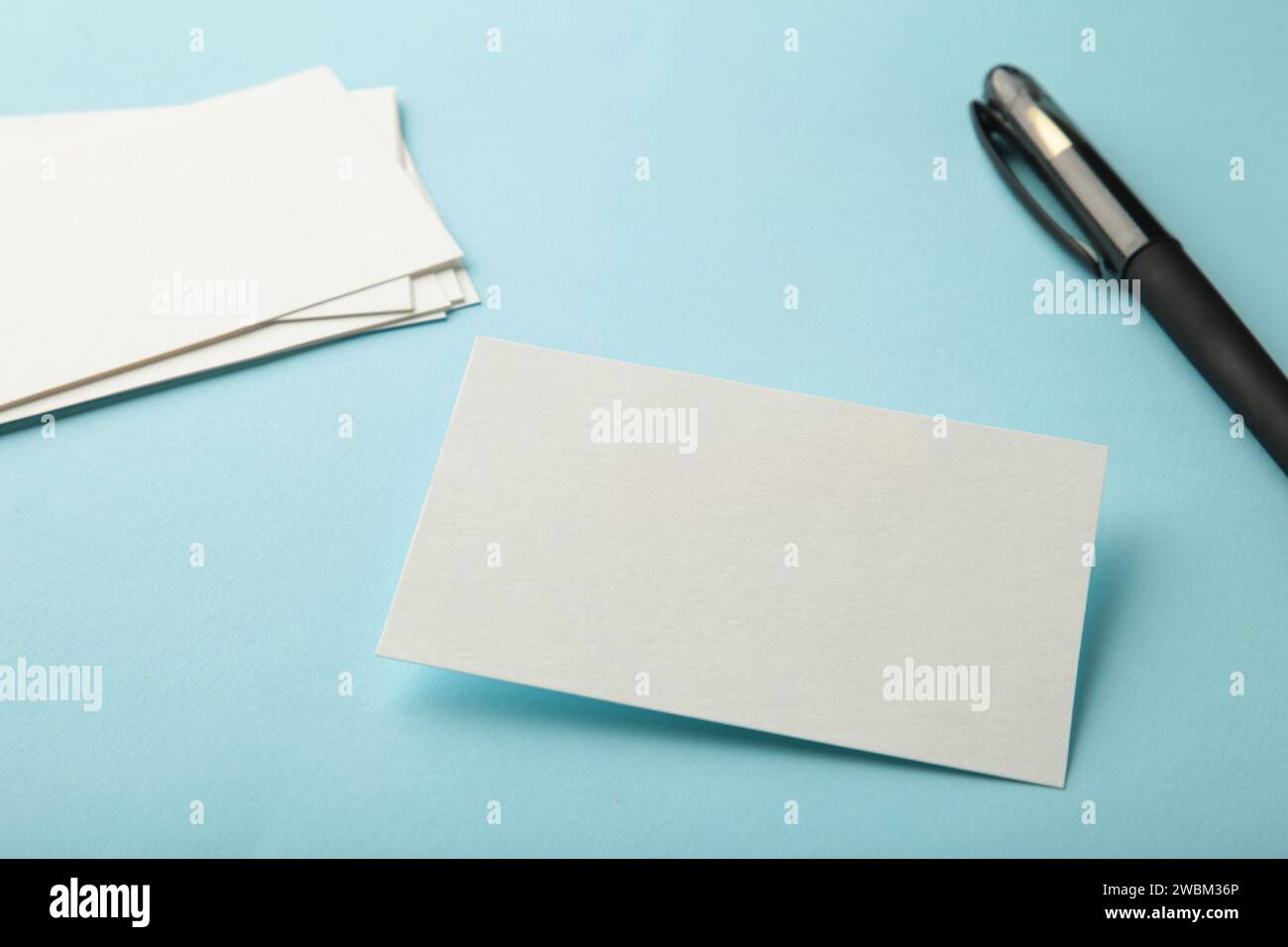 Leere weiße Visitenkarten auf blauem Papierhintergrund. Mockup für Markenidentität. Vorlage für Portfolios von Grafikdesignern. Stockfoto