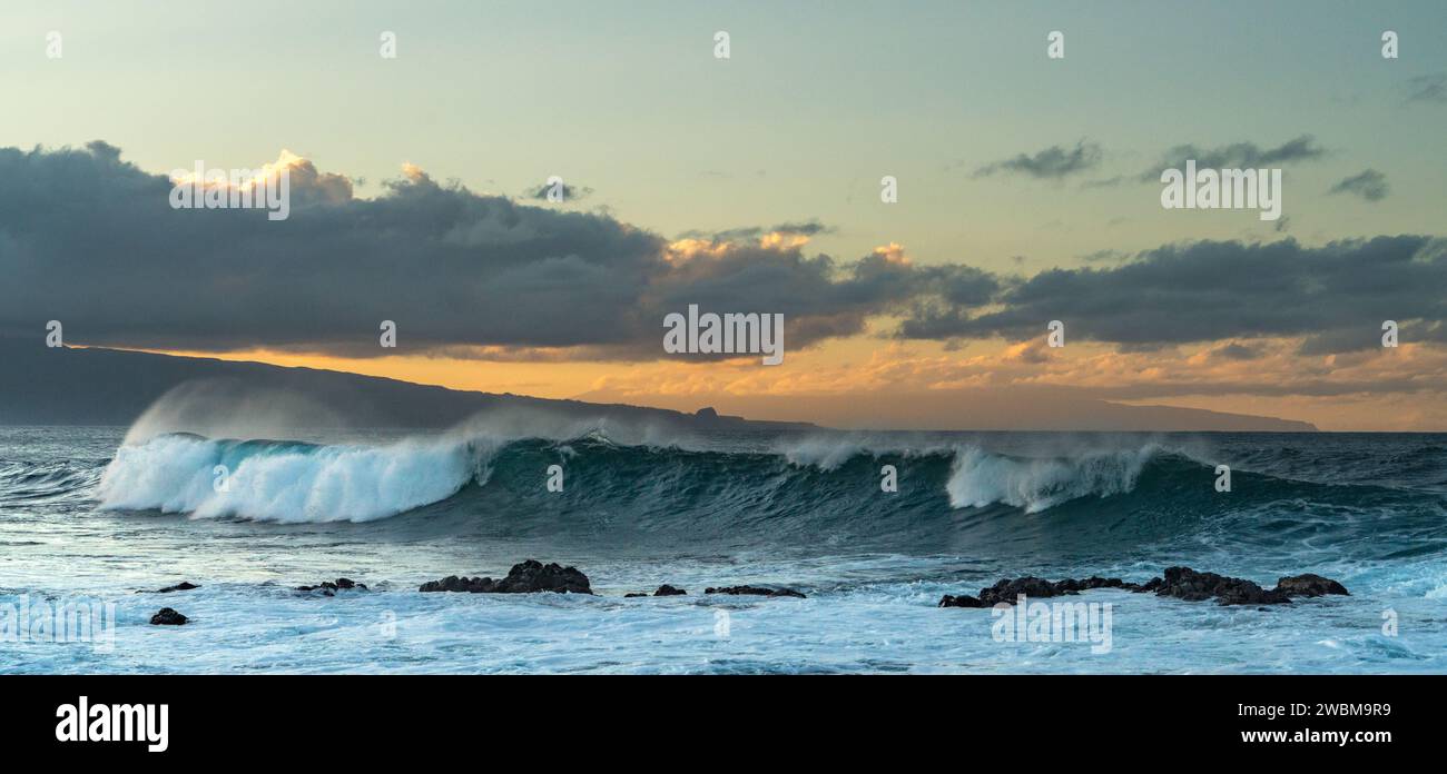 Die Sonne untergeht über Ho'okipa, wo die Wellen eine Symphonie der Pracht der Natur bilden. Stockfoto