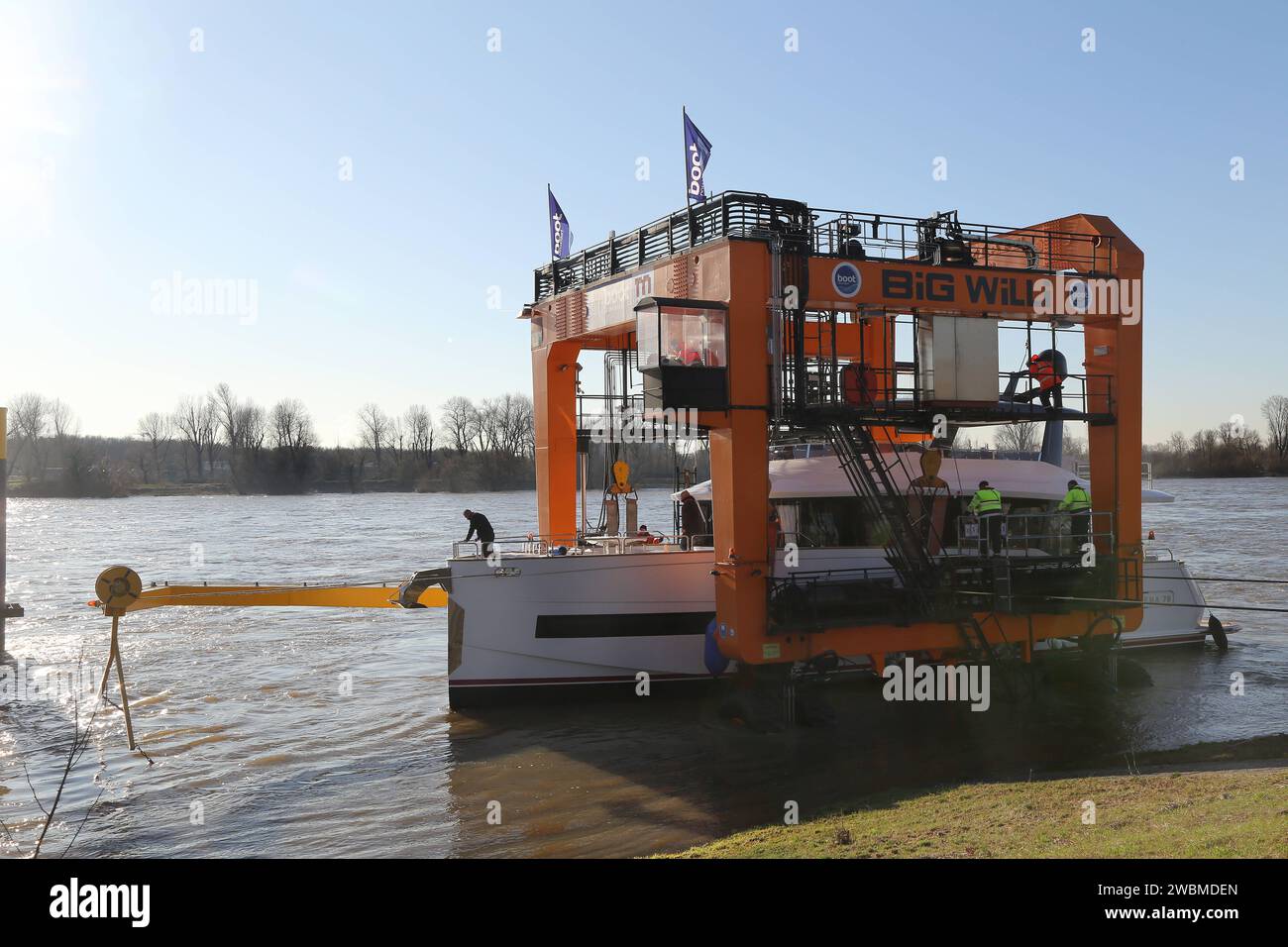 09.01.2024 Düsseldorf Bevor die Boot in Düsseldorf startet, werden zahlreiche der ausgestellten Yachten vom Rhein auf die Straße gebracht. Der orangene Schiffskran Big Willinimmt dort die Boote im Rhein auf und verladen sie auf Tieflader. Damit werden die Yachten in die Messehallen gefahren. Kranführer Norbert Pilarski steuert den großen Kran von oben. *** 09 01 2024 Düsseldorf bevor Boot in Düsseldorf startet, werden viele der gezeigten Yachten vom Rhein auf die Straße gebracht der orange Big willin Schiffskran nimmt die Boote im Rhein auf und lädt sie auf Tieflader so die Yacht Stockfoto