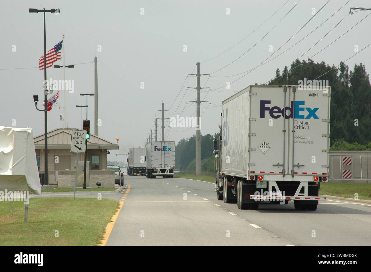 RAUMFAHRTZENTRUM KENNEDY, FLA. - Federal Express-Trucks mit Generatoren, Lichtern und Treibstoff fahren durch die Wachtore auf dem Weg zum Stennis Space Center in Mississippi. Stennis erlitt Schäden und Stromausfälle durch Hurrikan Katrina. KSC schickt einen Hubschrauber mit medizinischem Zubehör und einen medizinischen Notfalltechniker nach Stennis, dazu einen 1-Megawatt-Generator, 125- und 225-Kilowatt-Generatoren und 1.000 Gallonen Dieselkraftstoff. Die Michoud Assembly Facility in der Nähe von New Orleans war ebenfalls ohne Strom. Ein NASA-Flugzeug transportiert medizinische Vorräte, Lebensmittel und Kettensägen sowie einen Arzt und zwei Stockfoto