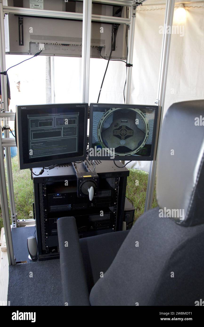 CAPE CANAVERAL, Fla. -- ein interaktiver Dockingsimulator, der von Lockheed Martin entwickelt wurde, gab STS-134 Startgästen im Kennedy Space Center der NASA in Florida die Möglichkeit, ein realistisches Andockmanöver mit der Internationalen Raumstation zu fliegen. Der mittlere Bildschirm zeigt die Vorwärtsansicht zum Andockziel, während der weiße T-förmige Griff für Übersetzungskorrekturen während des Manövers verwendet wird. Der für die STS-134-Mission Endeavour geplante Sensortest für Orion Relnav Risk Mitigation, oder STORRM, wird die Sensortechnologien ausgereift, um diese Docking-Operationen easi zu ermöglichen Stockfoto