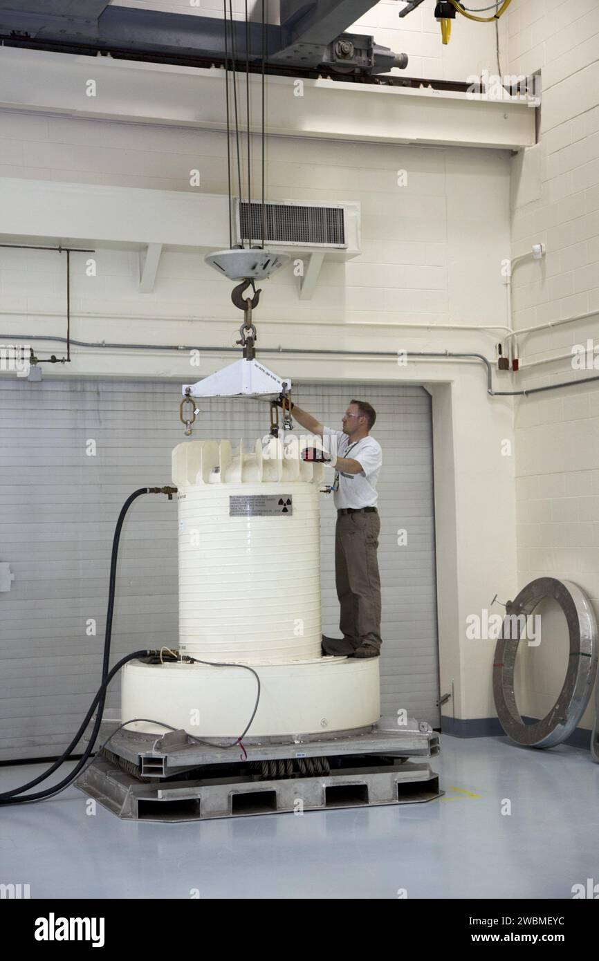 Ein Mitarbeiter des Energieministeriums befestigt einen Kran am MMRTG-Versandbehälter des Kennedy Space Centers für die Mission Mars Science Laboratory. Das MMRTG liefert kontinuierliche Plutonium-238-Leistung für Neugier und zirkuliert Wärme, um rover Instrumente und Systeme für die wissenschaftliche Untersuchung vergangener mikrobieller Umgebungen auf dem Mars aufrechtzuerhalten. Stockfoto