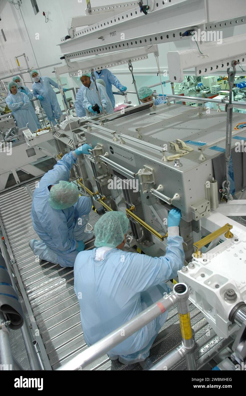 Die Arbeiter der Space Station Processing Facility heben das DTO-Fliesenprobenreparaturkit vom LMC ab, das vom Space Shuttle Discovery von STS-114 zurückgegeben wurde. Das Kit, das für Astronautenexperimente verwendet wird, wird an das Johnson Space Center in Houston geschickt. Stockfoto