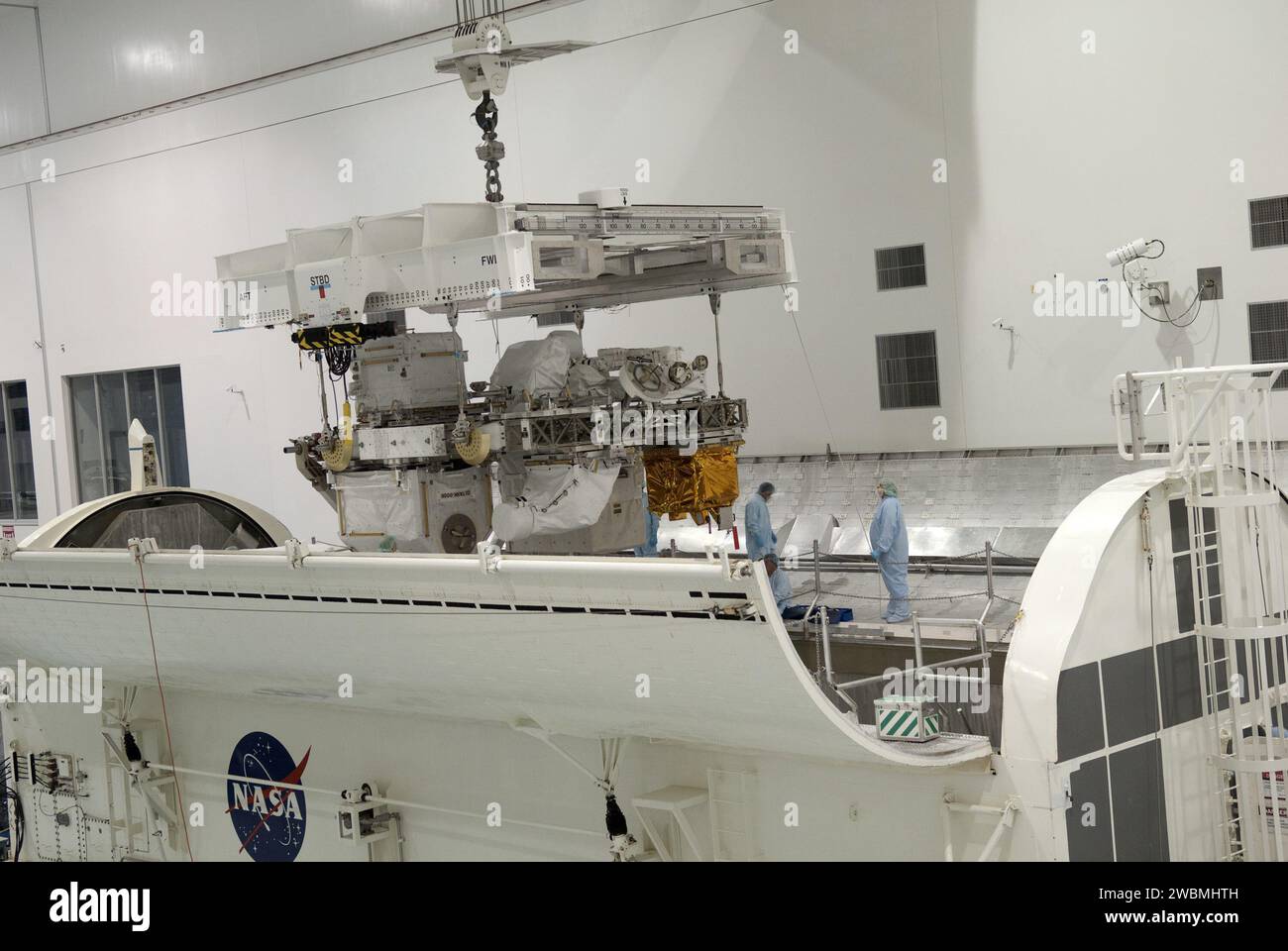 CAPE CANAVERAL, Fla. -- in der Space Station Processing Facility im Kennedy Space Center der NASA in Florida wird Express Logistics Carrier-3 in einen Nutzlastbehälter abgesenkt. Der Kanister wird die raumgebundene Nutzlast auf der Reise zum Launch Pad 39A schützen, wo sie später im Nutzlastbereich des Space Shuttle Endeavour installiert wird. ELC-3 ist mit einer Vielzahl von Ersatzteilen für die Internationale Raumstation ausgestattet, einschließlich zwei S-Band-Kommunikationsantennen, einem Hochdruckgastank, zusätzlichen Ersatzteilen für Dextre und Mikrometeoroid-Abschirmungen. ELC-3 fliegt an Bord zur Station Stockfoto