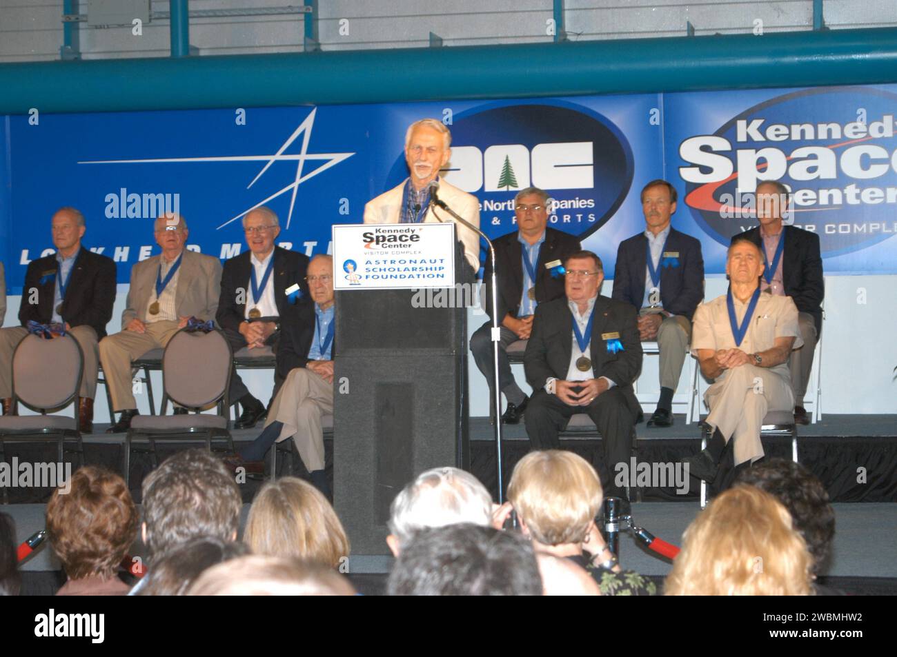 RAUMFAHRTZENTRUM KENNEDY, FLA. - Owen Garriott, Vorsitzender der Astronaut Hall of Fame, spricht mit Gästen bei der Einführungszeremonie von drei neuen Ergänzungen der Hall of Fame Gordon Fullerton, Bruce McCandless und Joe Allen. Auf der Bühne befinden sich die aktuelle Hall of Famers, von links in der hinteren Reihe Charles Duke, Jack Lousma, Bill Pogue, Dan Brandenstein, Robert „Hoot“ Gibson und Stephen Covey; in der ersten Reihe Jim Lovell, Fred Haise und Vance Brand. Diese Elite-Gruppe von Indu ist für ihre individuellen Flugleistungen und Beiträge zum Erfolg und zukünftigen Erfolg des US-Raumfahrtprogramms anerkannt Stockfoto