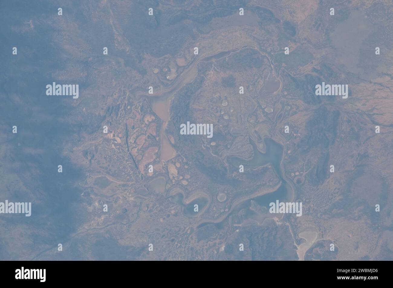 ISS028-E-014782 (6. Juli 2011) --- die Shoemaker (ehemals Teague) Impact Structure, die sich in Westaustralien in einem Entwässerungsbecken südlich der Waldburg Range befindet, präsentiert in diesem detaillierten Foto, das am 6. Juli von Bord der Internationalen Raumstation aufgenommen wurde, ein anderes Weltbild. Die Shoemaker-Einschlagstelle hat einen Durchmesser von etwa 30 Kilometern und ist klar definiert durch konzentrische Ringstrukturen, die in Sedimentgesteinen gebildet wurden (braun bis dunkelbraun, Bildmitte), die durch das Aufprallereignis vor etwa 1630 Millionen Jahren deformiert wurden, laut der Earth Impact Database. Sev Stockfoto