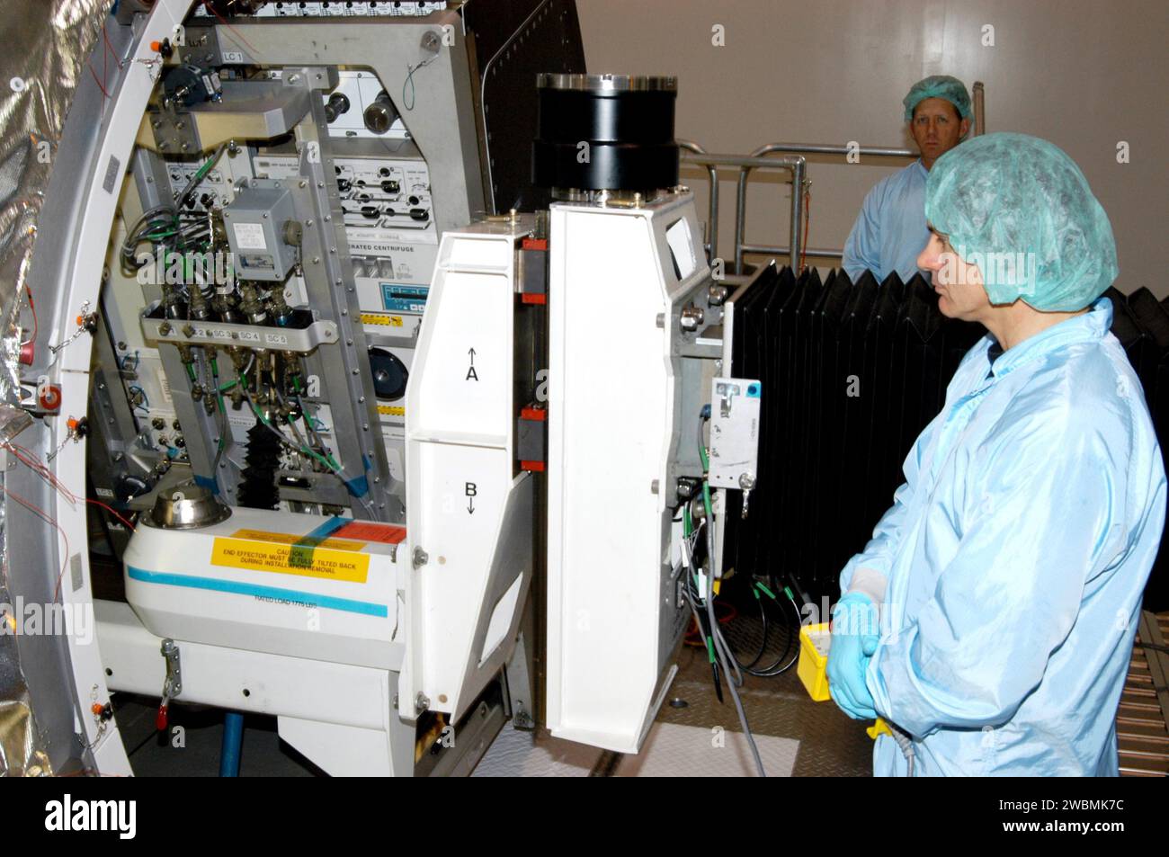 RAUMFAHRTZENTRUM KENNEDY, FLA. - In der Raumstation Processing Facility beobachtet ein Arbeiter, wie das Rack Insertion Device langsam das wissenschaftliche Rack der Human Research Facility-2 (HRF-2) in das Mehrzweck-Logistikmodul Raffaello für den Flug mit der Return to Flight Mission STS-114 des Space Shuttle Discovery bewegt. Die HRF-2 wird der Internationalen Raumstation zusätzliche biomedizinische Instrumente und Forschungskapazitäten zur Verfügung stellen. HRF-1, seit Mai 2001 im US-Labor installiert, enthält ein Ultraschallgerät und einen Gasanalysator. Beide Racks bieten Struktur-, Strom-, Wärme-, Befehls- und Datenverarbeitung und Stockfoto