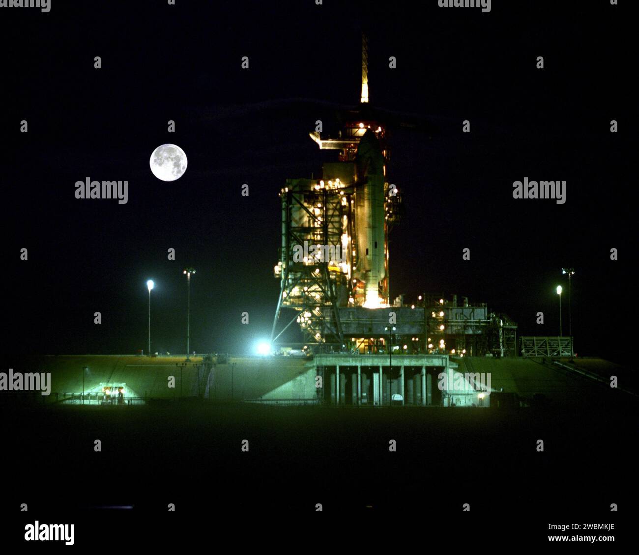 Das STS-1 Space Shuttle Columbia mit externem Tank und festen Raketenverstärkern wird auf dem Kennedy Space Center mit dem Mond im Hintergrund vorbereitet. Stockfoto