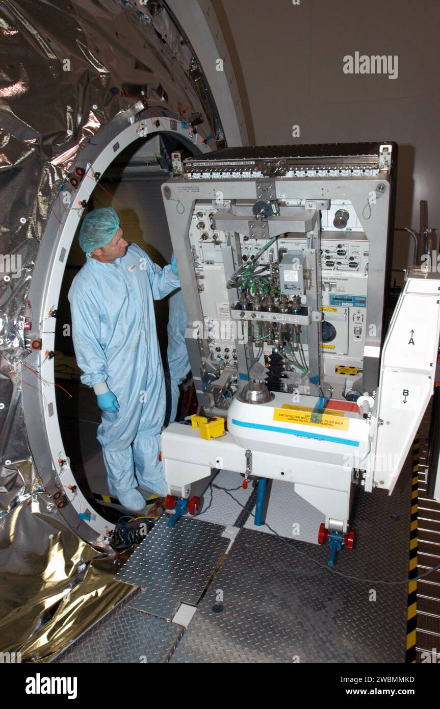 RAUMFAHRTZENTRUM KENNEDY, FLA. - In der Raumstation-Verarbeitungsanlage steht ein Arbeiter zur Seite, während die Rack-Einfügevorrichtung langsam das wissenschaftliche Rack der Human Research Facility-2 (HRF-2) in das Mehrzwecklogistik-Modul Raffaello für den Flug mit der Return to Flight Mission STS-114 des Space Shuttle Discovery verschiebt. Die HRF-2 wird der Internationalen Raumstation zusätzliche biomedizinische Instrumente und Forschungskapazitäten zur Verfügung stellen. HRF-1, seit Mai 2001 im US-Labor installiert, enthält ein Ultraschallgerät und einen Gasanalysator. Beide Racks bieten Struktur-, Strom-, Wärme-, Befehls- und Datenverarbeitung, ein Stockfoto