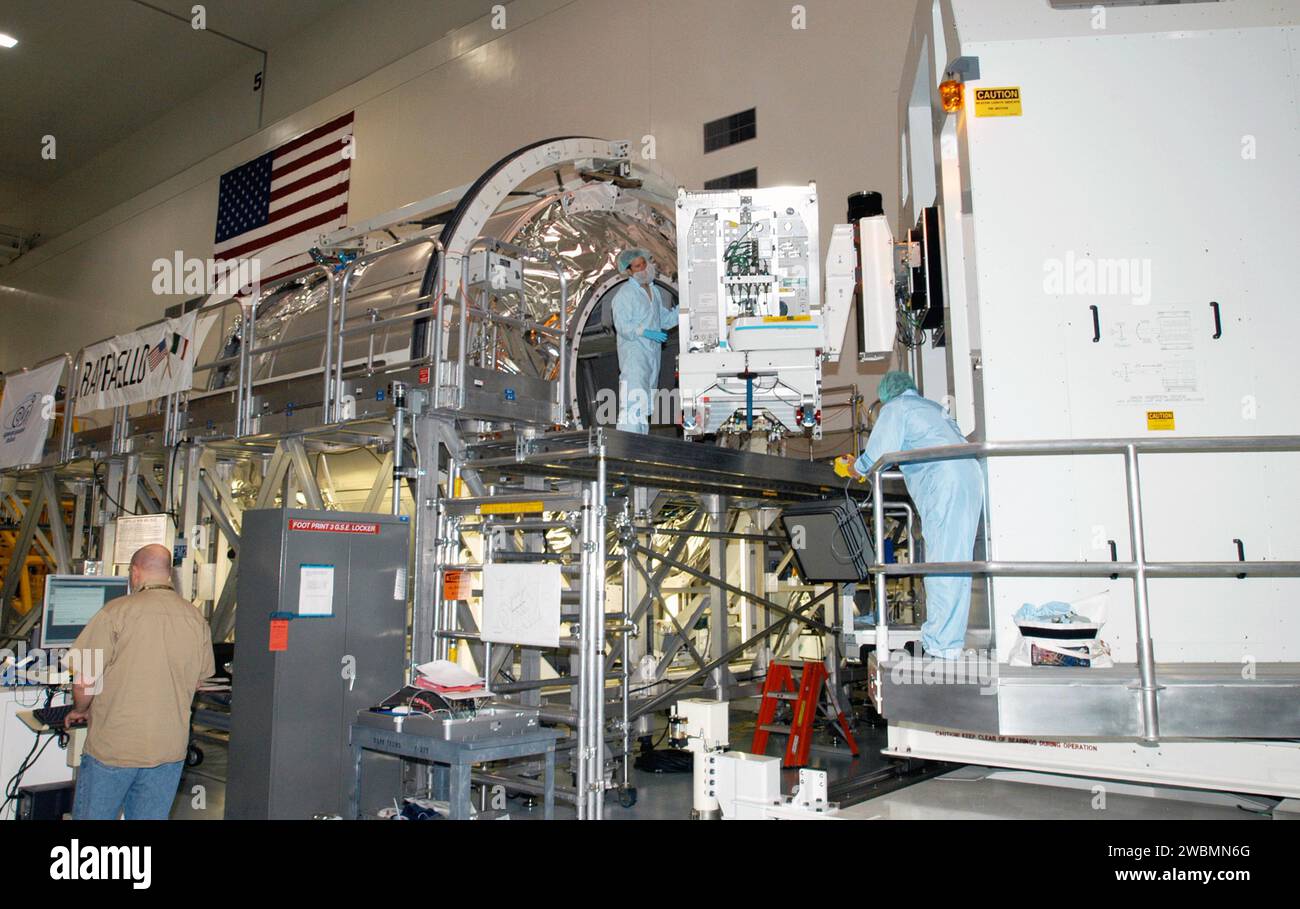 RAUMFAHRTZENTRUM KENNEDY, FLA. - In der Space Station Processing Facility verschiebt das Rack Insertion Device das wissenschaftliche Rack der Human Research Facility-2 (HRF-2) zum Mehrzwecklogistik-Modul Raffaello (links) für den Flug mit der Return to Flight Mission STS-114 des Space Shuttle Discovery. Die HRF-2 wird der Internationalen Raumstation zusätzliche biomedizinische Instrumente und Forschungskapazitäten zur Verfügung stellen. HRF-1, seit Mai 2001 im US-Labor installiert, enthält ein Ultraschallgerät und einen Gasanalysator. Beide Racks bieten Struktur-, Strom-, Wärme-, Befehls- und Datenverarbeitung sowie Kommunikation A Stockfoto