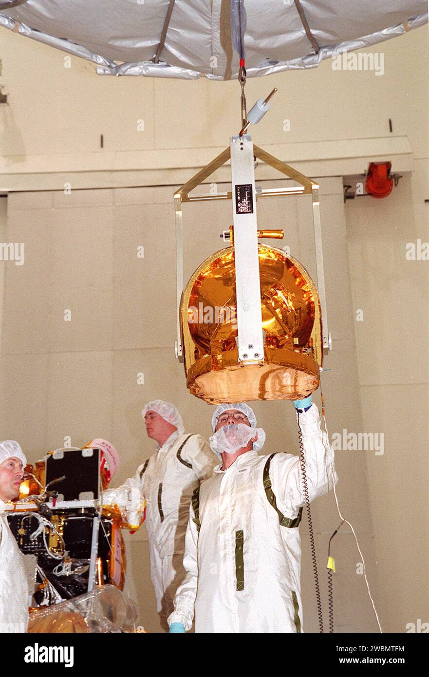Techniker führen das Gamma-Ray-Spektrometer (GRS) zur Installation auf dem Mars-Odyssey-Orbiter in der Raumfahrzeug-Assembly- und Kapselungsanlage 2 (SAEF 2). Der Orbiter wird drei wissenschaftliche Instrumente tragen: Das Thermal Emission Imaging System (THEMIS), das Gamma-Ray-Spektrometer (GRS) und das Mars Radiation Environment Experiment (MARIE). THEMIS wird die Mineralogie und Morphologie der Marsoberfläche mit einer hochauflösenden Kamera und einem Infrarot-Spektrometer kartieren. Die GRS wird eine globale Kartierung der Elementzusammensetzung der Oberfläche erreichen und die abu bestimmen Stockfoto
