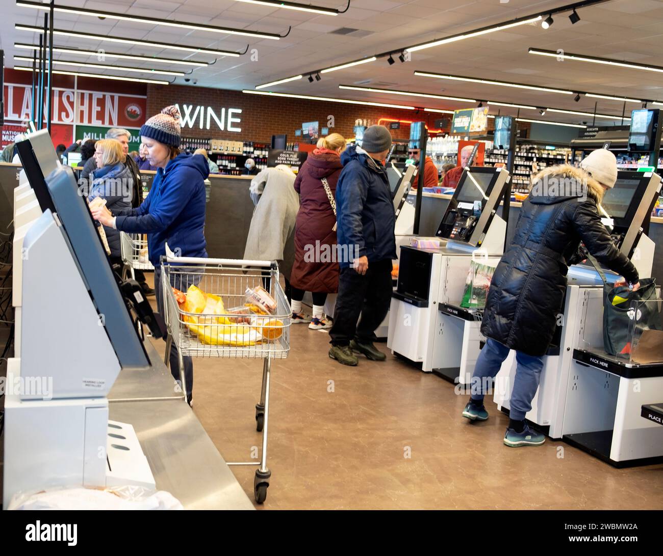 M&S Marks and Spencer Supermarkt Inneneinrichtung Menschen Kunden Käufer zahlen für Selbstbedienungskassen Januar 2024 UK KATHY DEWITT Stockfoto
