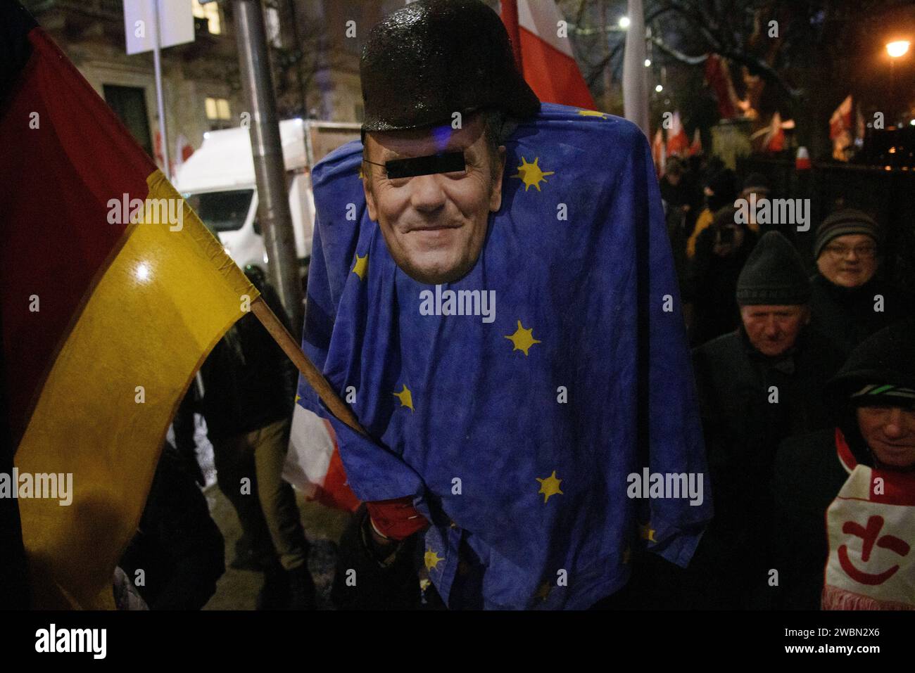Anti-Regierungs-Protest In Warschau. Ein Demonstrant trägt ein Modell des polnischen Ministerpräsidenten Donald Tusk, der einen deutschen Helm aus dem Zweiten Weltkrieg trägt, in eine Flagge der Europäischen Union gehüllt ist und eine deutsche Flagge hält, während er am 11. Januar 2024 an einer Anti-Regierungs-Kundgebung in Warschau teilnimmt. Tausende von Menschen versammelten sich vor dem polnischen parlament des Sejm, um gegen die proeuropäische Koalition unter der Führung von Donald Tusk zu protestieren, die die Freilassung der Abgeordneten Mariusz Kaminski und Maciej Wasik der Partei Recht und Gerechtigkeit der PiS forderte, sowie die Rückkehr der staatlichen Medien unter dem Einfluss der PiS. Warschau Polen Copyright: XAleksanderxKalka Stockfoto