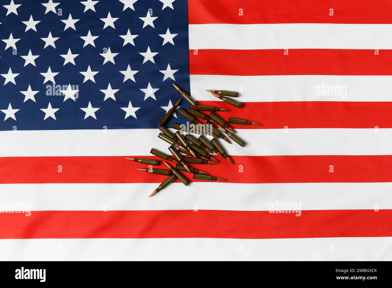 Kugeln für Schusswaffen, Kampfarmee-Patronen auf der amerikanischen Flagge, Draufsicht. Das Konzept des Leihpachtvertrags, der Lieferung von Waffen, der Unterstützung, des Waffenverkaufs. Stockfoto