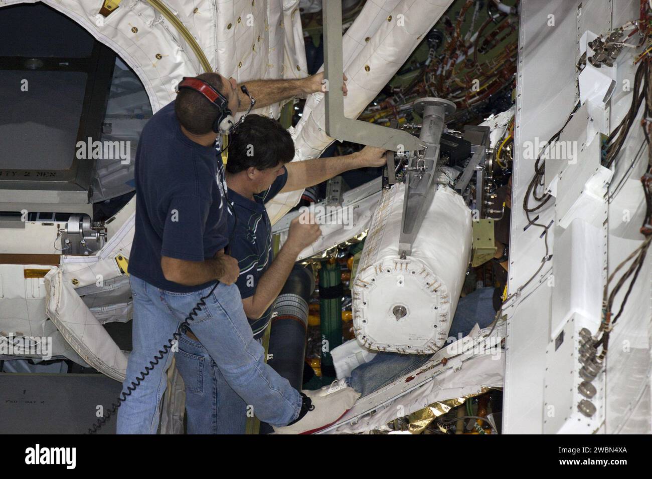 CAPE CANAVERAL, Fla. – Innerhalb der Orbiter Processing Facility-2 im Kennedy Space Center der NASA in Florida helfen Techniker dabei, eine der drei Brennstoffzellen mit einem Spezialkran aus der Nutzladerampe des Space Shuttle Atlantis zu heben. Alle Flüssigkeiten werden aus den Brennstoffzellen abgelassen. Die Wasserstoff- und Sauerstoff-Dewars, die den Brennstoffzellen Reaktanten zuführen, verbleiben im mittleren Körper von Atlantis und werden mit inerten Gasen gespült und abgelassen. Die Arbeit ist Teil der Übergangs- und Pensionierung des Shuttles Atlantis. Der Orbiter wird für die Ausstellung im Kennedy Space vorbereitet Stockfoto