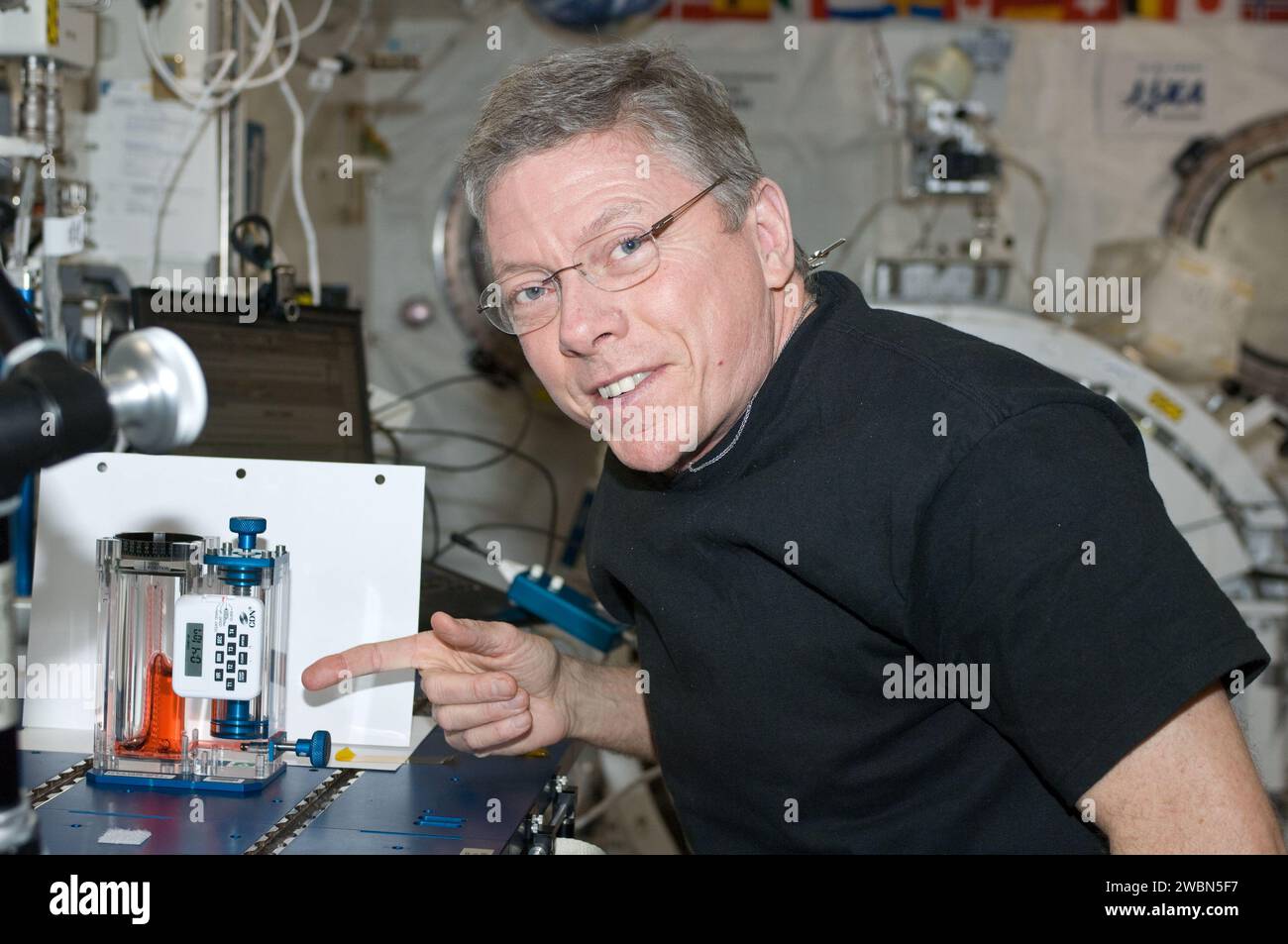 ISS029-E-020901 (7. Oktober 2011) --- NASA-Astronaut Mike Fossum, Kommandeur der Expedition 29, verweist auf das Kapillarfluss-Experiment (CFE) im Kibo-Labor der Internationalen Raumstation. Stockfoto