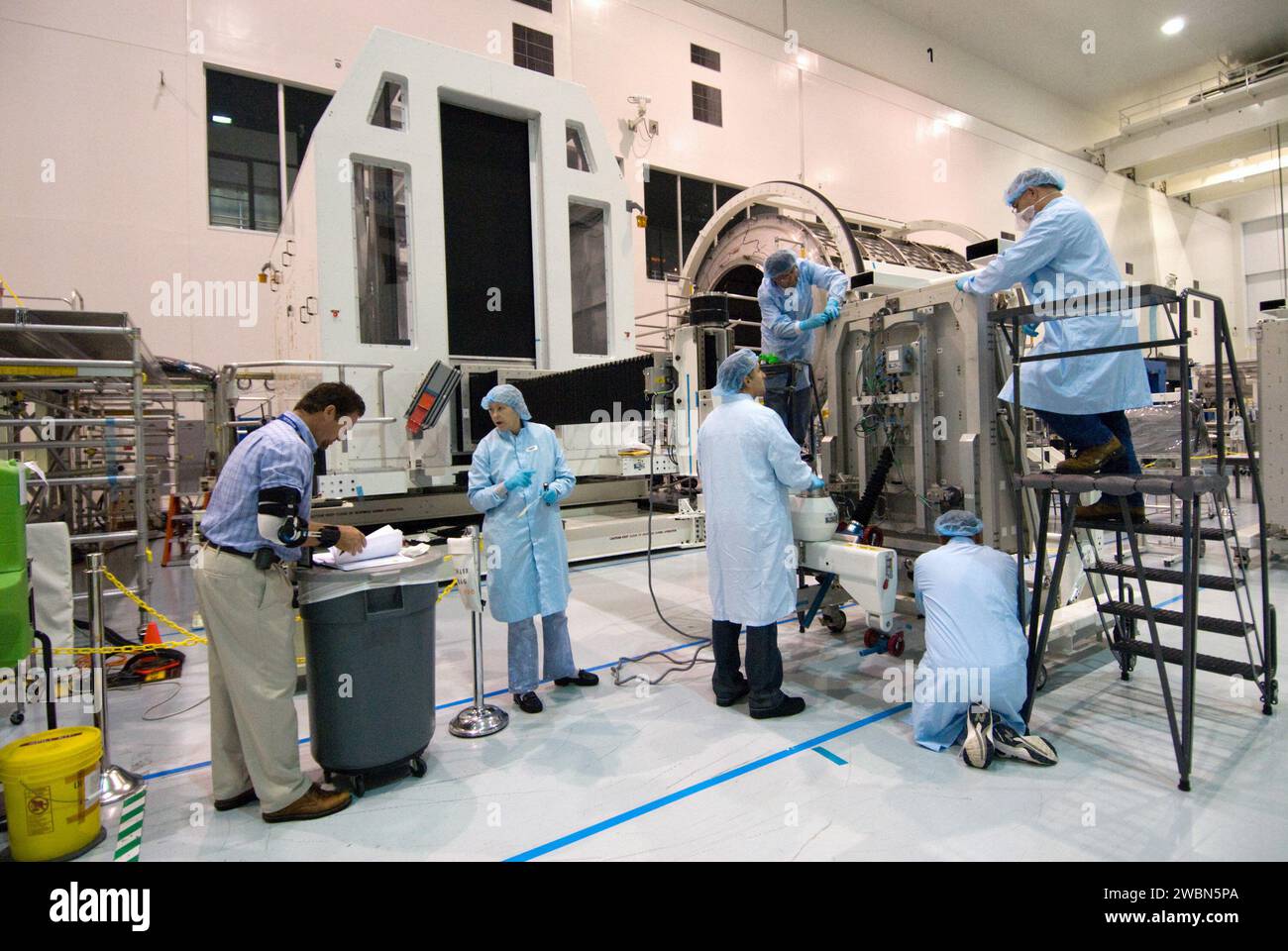 CAPE CANAVERAL, Fla. - In der Raumstation-Verarbeitungsanlage im Kennedy Space Center der NASA in Florida, ist der Systemingenieur Ken Koby für Mehrzweck-Logistikmodule links. und ein Team von Boeing-Technikern bereitet sich darauf vor, während der Bearbeitung der STS-131-Mission des Space Shuttle Discovery zur Internationalen Raumstation eine Nachspeiseplattform im Mehrzweck-Logistikmodul Leonardo zu installieren. Die an den Regalen und Bahnsteigen von Leonardo gelieferte Ladung wird an Standorte im gesamten Bahnhof transportiert. Bei drei Raumwanderungen während STS-131 wird ein Ersatz-Ammoniak ta angebracht Stockfoto