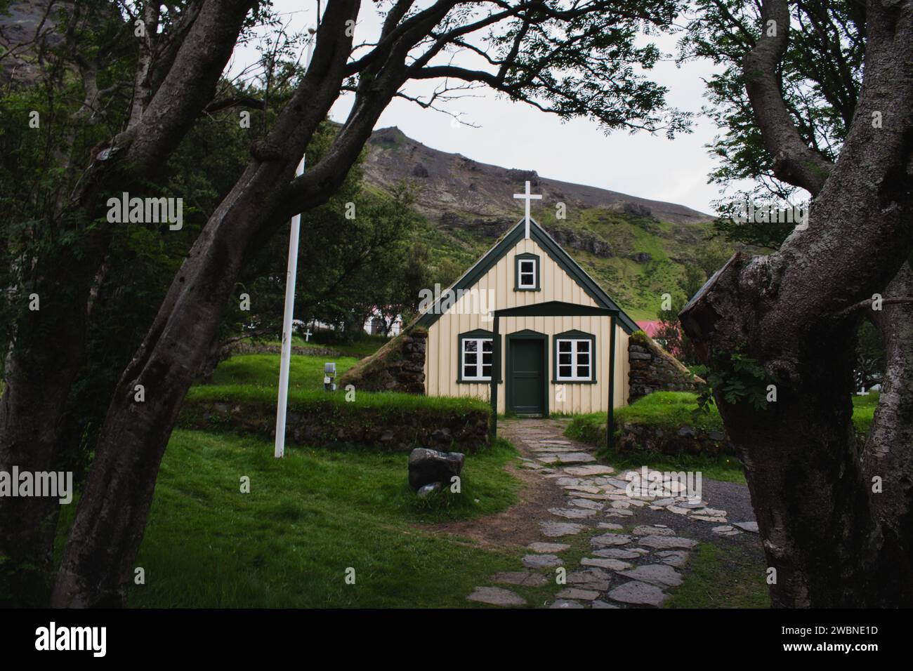 Grasbewachsener Kirchenfriedhof mit Moosdach in Island Stockfoto