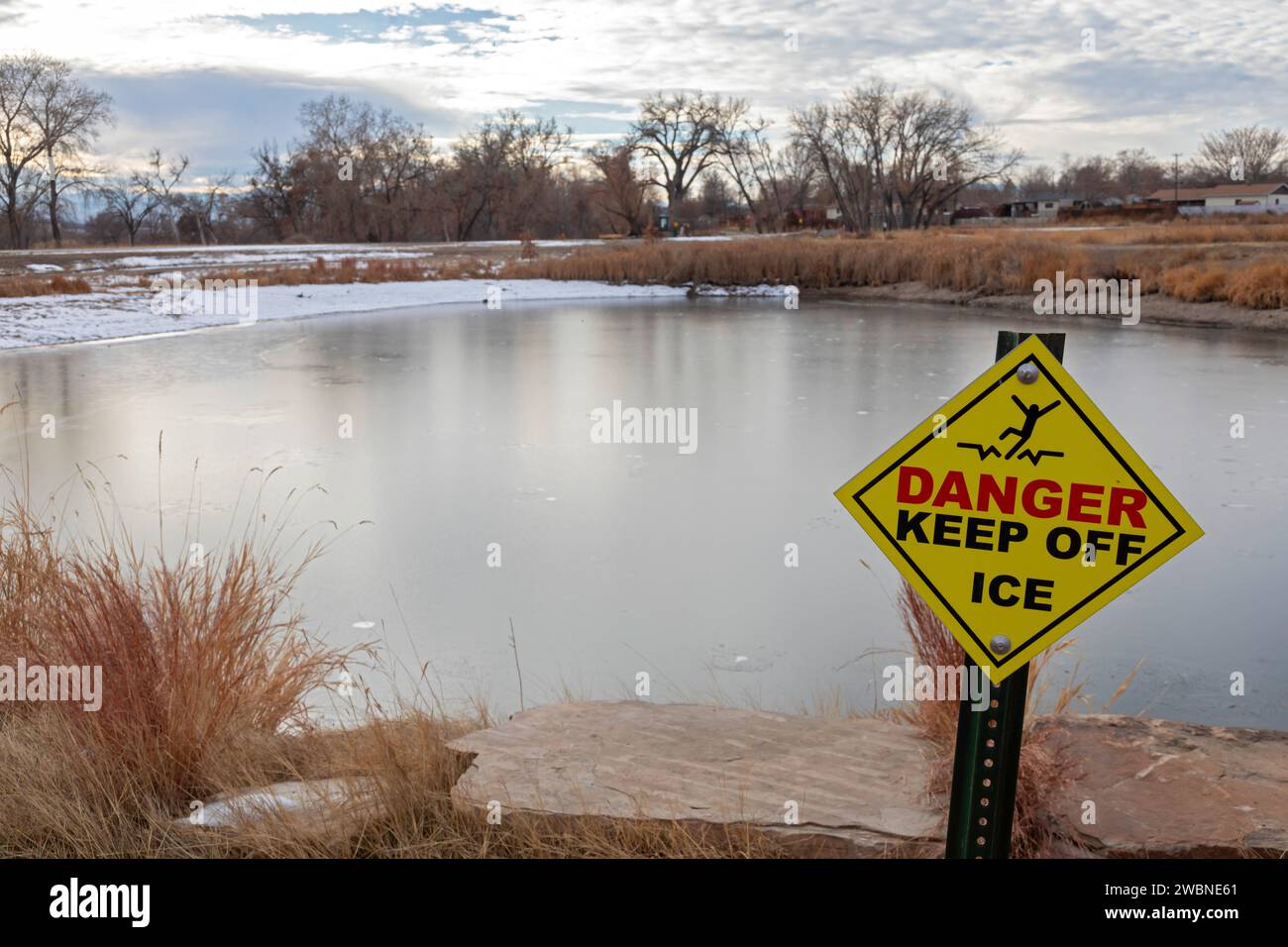 Denver, Colorado – Ein Schild warnt vor dünnem Eis auf einem Teich entlang des Clear Creek Trail. Der Wander-/Radweg verläuft 30 km von Golden, Colorado bis zum Stockfoto