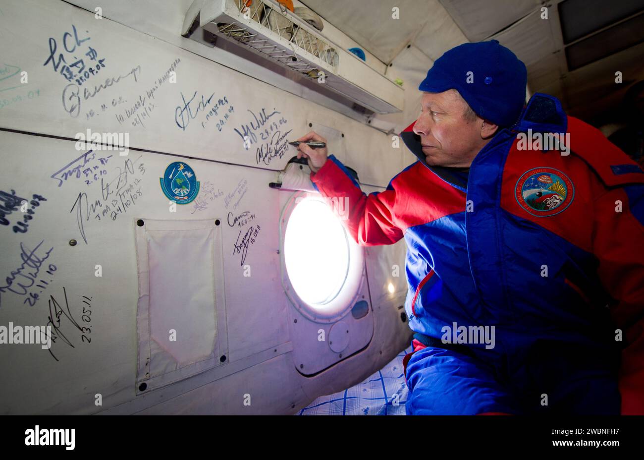 Der Kommandant der Expedition 29, Mike Fossum, unterzeichnete den russischen Such- und Rettungshubschrauber, nachdem er am 22. November 2011 mit den Flugingenieuren Sergei Volkov und Satoshi Furukawa in Sojus TMA-02M in der Nähe von Arkalyk, Kasachstan, gelandet war. Stockfoto