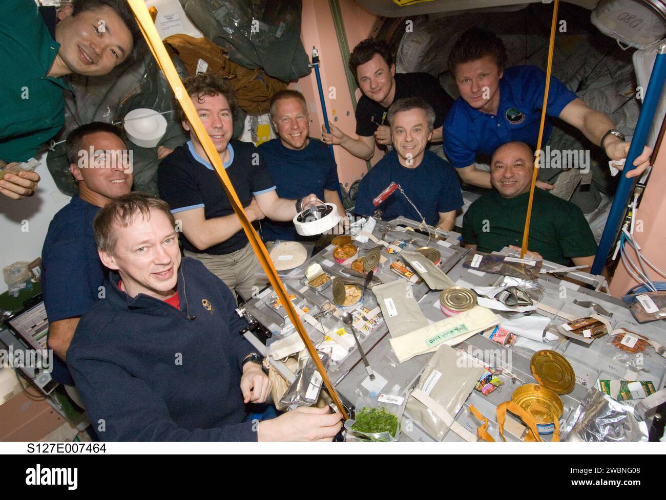 S127-E-007464 (21. Juli 2009) --- neun der insgesamt 13 Astronauten und Kosmonauten sind während der Mahlzeiten an Bord der Internationalen Raumstation abgebildet. Am Tisch sitzen im Uhrzeigersinn von unten links der Astronaut Frank de Winne, der Astronaut Christopher Cassidy, die Astronauten Mike Barratt und Tim Kopra sowie der Astronaut Robert Thirsk und Mark Polansky. Von links nach rechts oben sind der japanische Astronaut Koichi Wakata und die Kosmonauten Roman Romanenko und Gennady Padalka. Nicht p Stockfoto