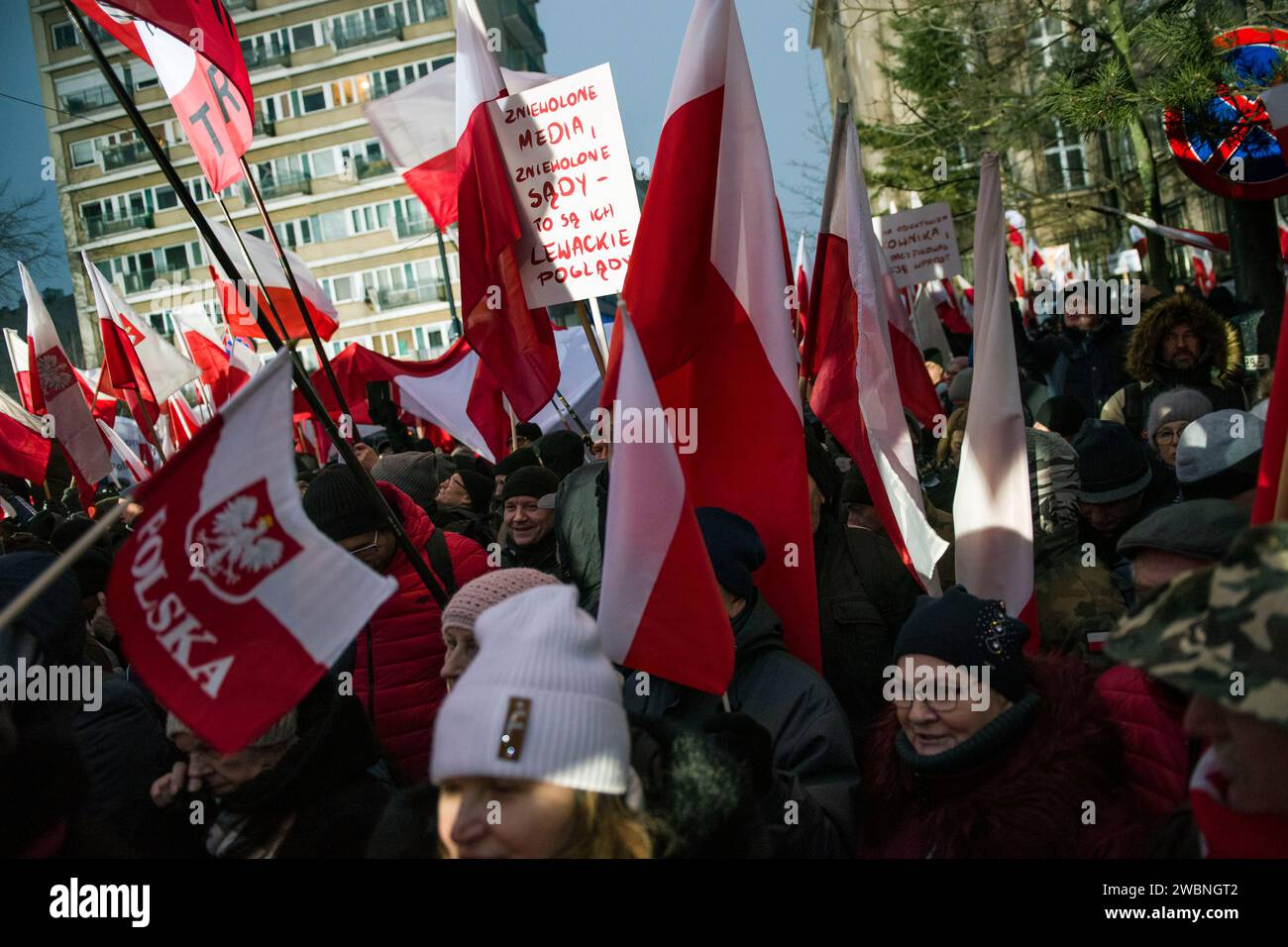 Tausende Demonstranten schwenken polnische Fahnen und halten Plakate bei der Demonstration. Polens rechte Opposition, frustriert über den jüngsten Machtverlust, forderte seine Anhänger auf, gegen die Schritte der neuen pro-europäischen Regierung zu protestieren, die Kontrolle über die staatlichen Rundfunkanstalten und die staatliche Nachrichtenagentur zu übernehmen. Die Partei Recht und Gerechtigkeit (PiS), die acht Jahre lang regierte, bevor sie die Parlamentswahlen im Oktober verlor, rief zu einem Protest unter dem Motto „Protest der Freien Polen“ (Protest Wolnych Polakow) vor dem parlament auf. Sie stellte den Protest als Verteidigung der Demokratie und der freien Medien dar. Stockfoto