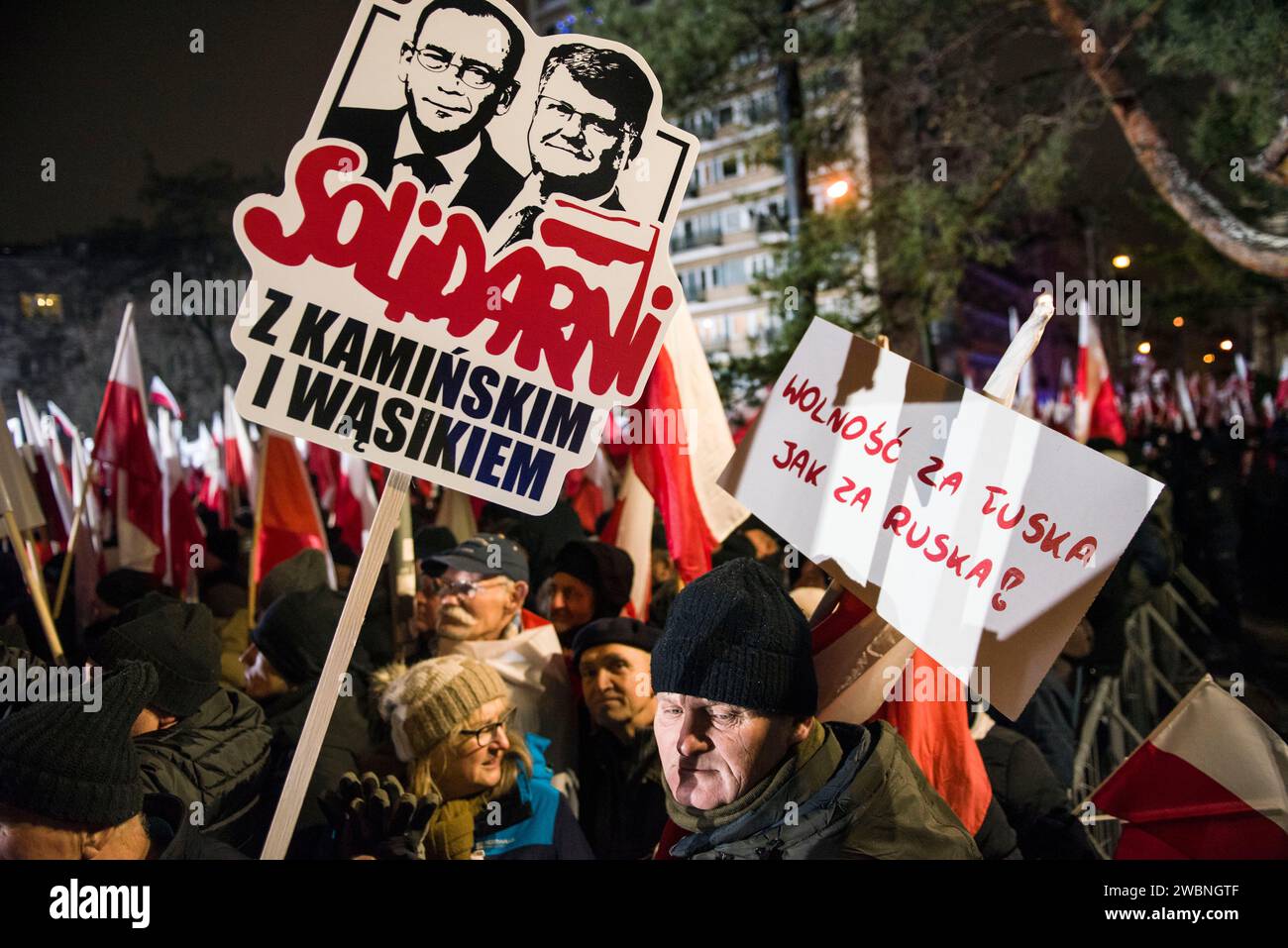 Ein Demonstrant hält während der Demonstration ein Plakat mit der Aufschrift Solidarität mit Kaminski und Wasik. Polens rechte Opposition, frustriert über den jüngsten Machtverlust, forderte seine Anhänger auf, gegen die Schritte der neuen pro-europäischen Regierung zu protestieren, die Kontrolle über die staatlichen Rundfunkanstalten und die staatliche Nachrichtenagentur zu übernehmen. Die Partei Recht und Gerechtigkeit (PiS), die acht Jahre lang regierte, bevor sie die Parlamentswahlen im Oktober verlor, rief zu einem Protest unter dem Motto „Protest der Freien Polen“ (Protest Wolnych Polakow) vor dem parlament auf. Sie stellte den Protest als Verteidigung der Demokratie dar Stockfoto