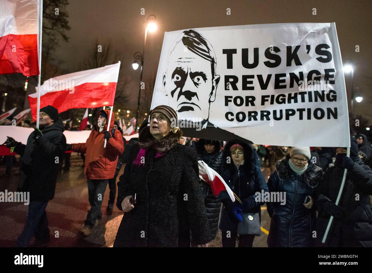 Die Demonstranten halten ein Anti-Tusk-Banner und schwenken polnische Fahnen während der Demonstration. Polens rechte Opposition, frustriert über den jüngsten Machtverlust, forderte seine Anhänger auf, gegen die Schritte der neuen pro-europäischen Regierung zu protestieren, die Kontrolle über die staatlichen Rundfunkanstalten und die staatliche Nachrichtenagentur zu übernehmen. Die Partei Recht und Gerechtigkeit (PiS), die acht Jahre lang regierte, bevor sie die Parlamentswahlen im Oktober verlor, rief zu einem Protest unter dem Motto „Protest der Freien Polen“ (Protest Wolnych Polakow) vor dem parlament auf. Er stellte den Protest als Verteidigung der Demokratie und der freien Medien dar Stockfoto