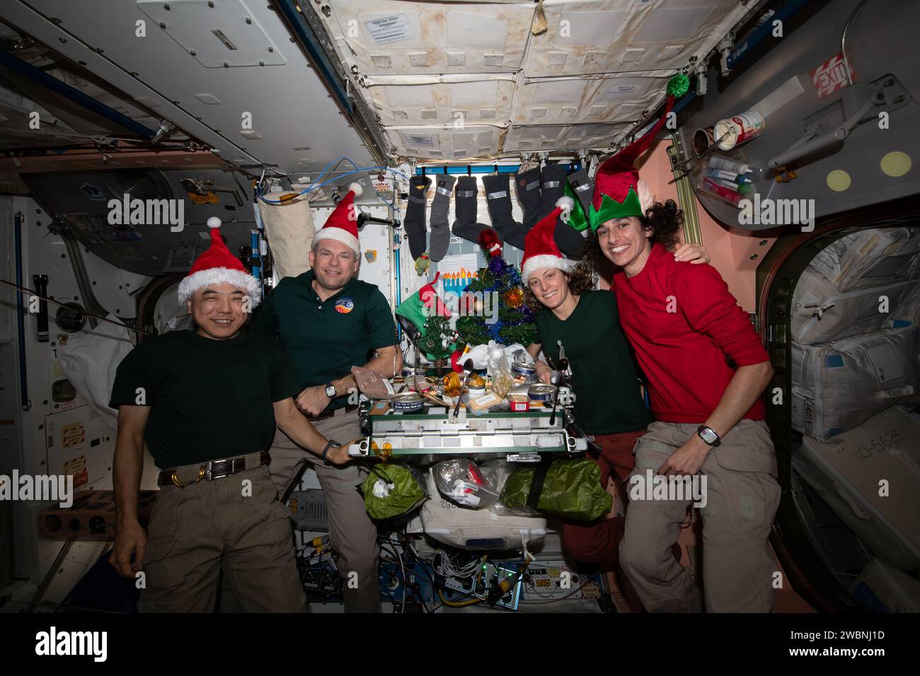 Iss070e044842 (25. Dezember 2023) --- vier Besatzungsmitglieder der Expedition 70 schließen sich im Einheitsmodul der Internationalen Raumstation zu einem Weihnachtsessen an. Von links sind Flugingenieur Koichi Wakata von der JAXA (Japan Aerospace Exploration Agency), Kommandant Andreas Mogensen von der ESA (European Space Agency) und die NASA-Flugingenieure Loral O'Hara und Jasmin Moghbeli. Stockfoto