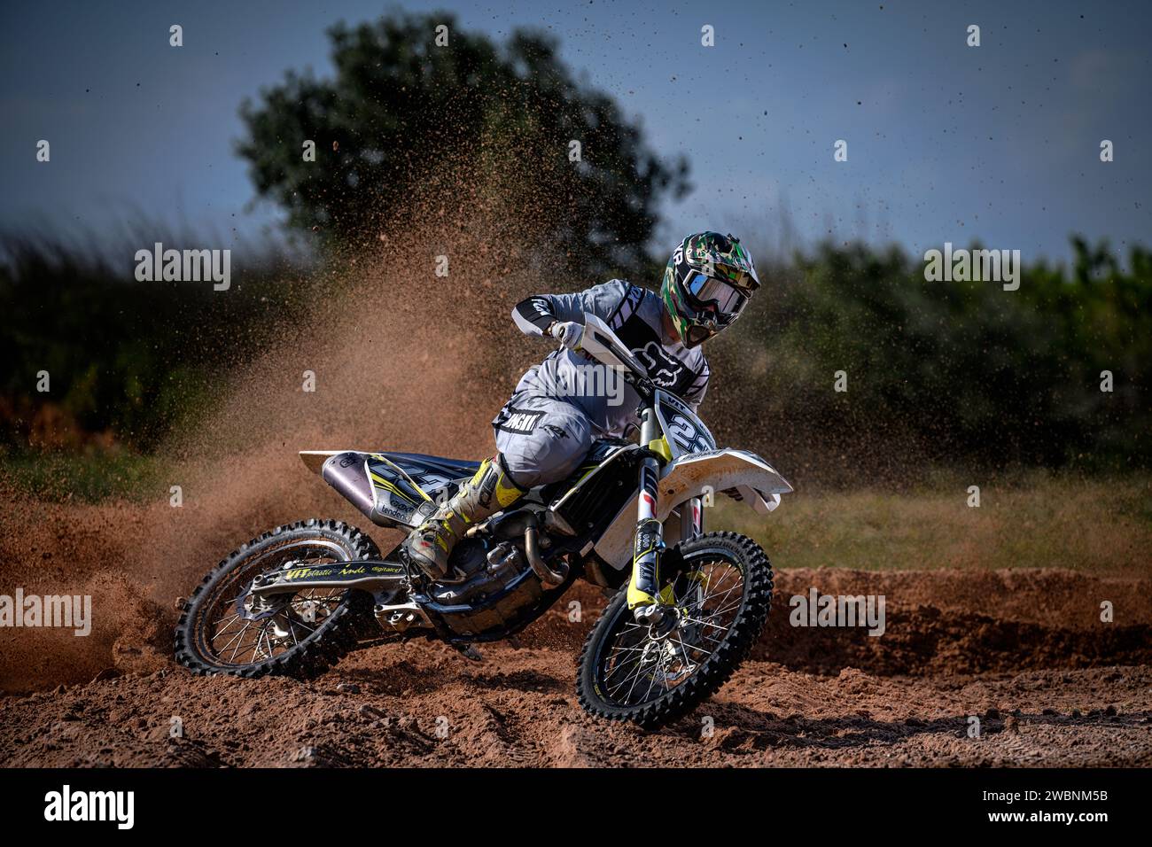 Motocross-Fahrer in Aktion mit Geschwindigkeit zur Kamera und hebe Schlamm, Steine und Schmutz. Stockfoto