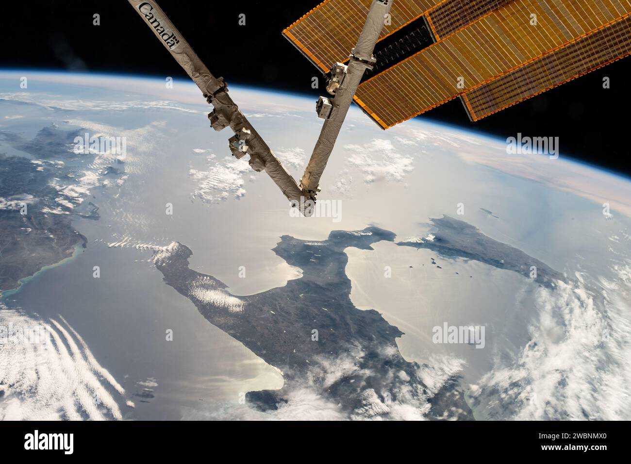 Iss070e007587 (20. Oktober 2023) --- der Stiefel Italiens und der Insel Sizilien ist von der Internationalen Raumstation aus abgebildet, wie sie 262 Meilen über dem Meeresspiegel umkreist hat. Im Vordergrund erstrecken sich der Canadarm2 Roboterarm und ein Paar der wichtigsten Solararrays aus dem umlaufenden Labor. Stockfoto