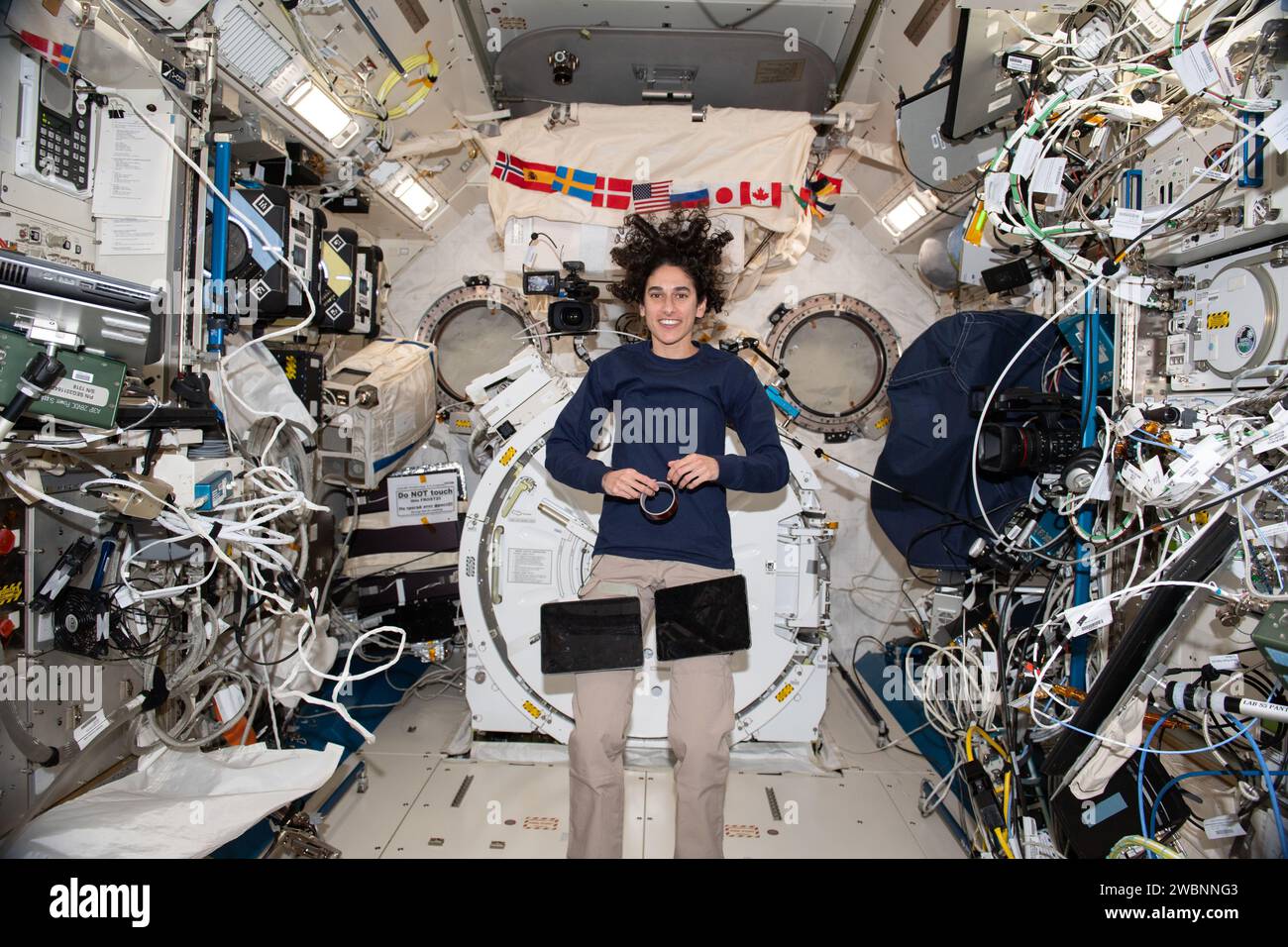 Iss070e035105 (30. November 2023) --- NASA-Astronaut und Expedition 70 Flugingenieur Jasmin Moghbeli macht während der Operation eine Pause und posiert für ein Porträt im Kibo-Labormodul der Internationalen Raumstation. Ein Paar Computer-Tablets sind an Klettverschlüssen an Moghbelis Hosen befestigt, um den Zugang beim Durchlesen von Verfahren und Anweisungen zu erleichtern. Stockfoto