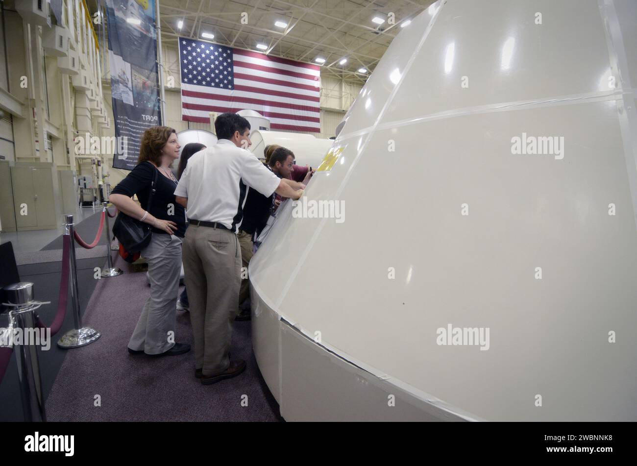 NASA-Tweetup-Teilnehmer untersuchen das Orion-Modell mit niedriger Wiedergabetreue in Gebäude 9 im Johnson Space Center, Houston, am 19. Juli 2011. Stockfoto