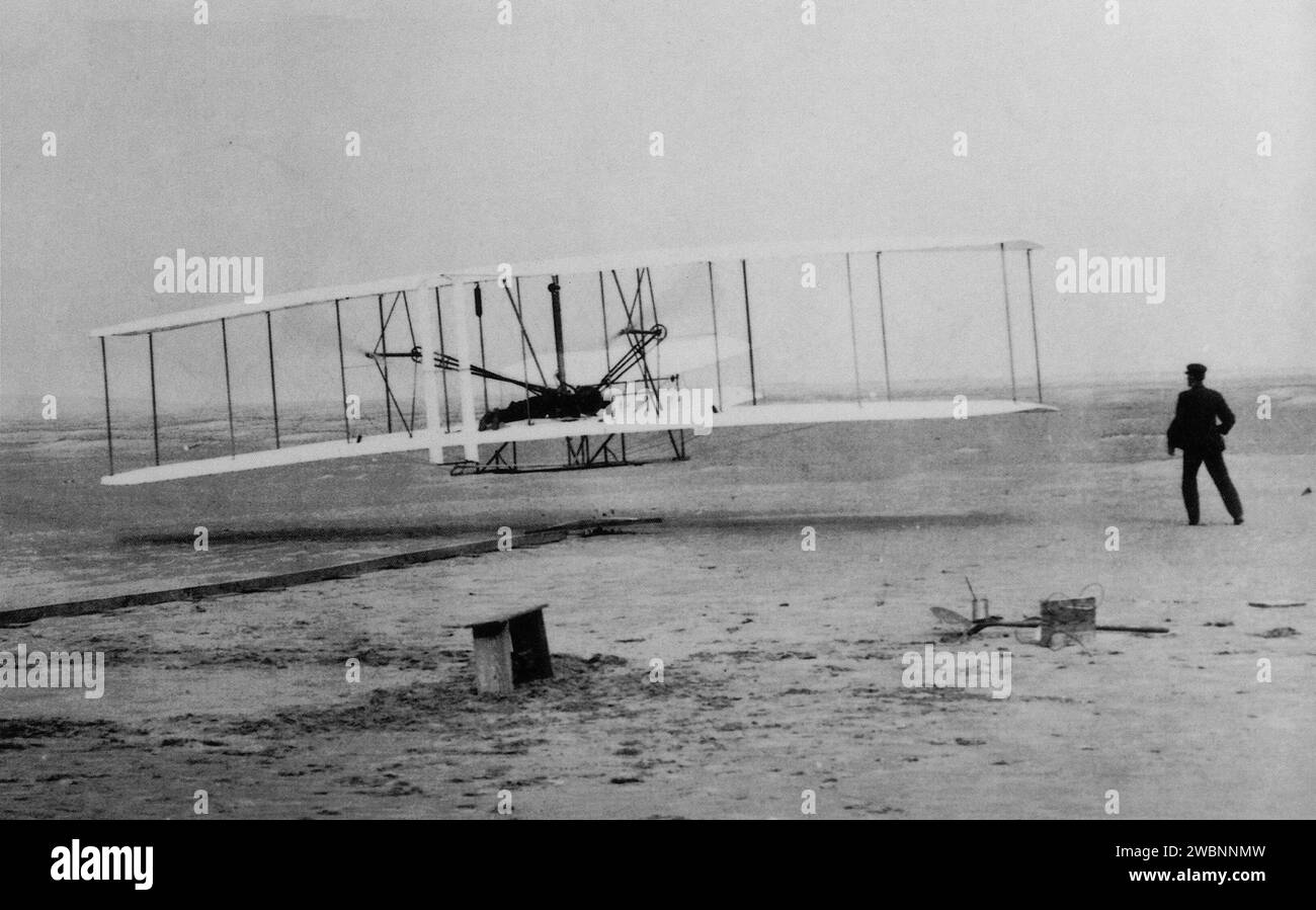 Am 17. Dezember 1903 gelang es den Brüdern Wilbur und Orville Wright aus Dayton, Ohio, ein Flugzeug zu fliegen, das sie bauten. Ihr Triebflugzeug flog 12 Sekunden lang über den Sanddünen von Kitty Hawk, North Carolina, und war damit die ersten Männer, die eine Maschine mit mehr als Luft steuerten, die mit eigener Kraft startete, unter Kontrolle blieb und den Flug aufrechterhielt. Stockfoto