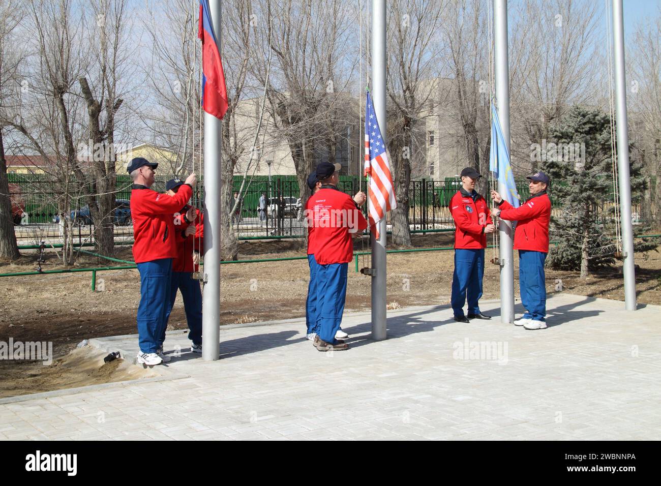 Vor dem Cosmonaut Hotel in Baikonur, Kasachstan, führten die Mitglieder der Expedition 27 am 23. März 2011 im Rahmen ihrer traditionellen Aktivitäten vor dem Start das zeremonielle Hissen der russischen, US- und kasachischen Flaggen durch. Von links nach rechts sind die wichtigsten russischen Besatzungsmitglieder Alexander Samokutyaev und Andrey Borisenko, der führende NASA-Flugingenieur Ron Garan (Mitte) und sein Stellvertreter Dan Burbank sowie die russischen Hilfskräfte Anton Schkaplerow und Anatoly Iwanishin. Garan, Samokutyaev und Borisenko sollen am 5. April (4. April, US-Zeit) von der Ba starten Stockfoto